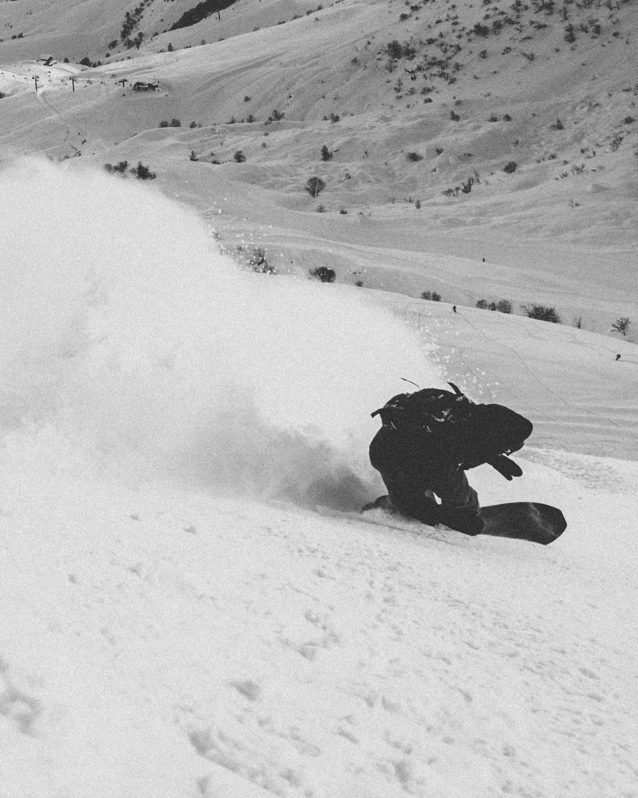 us shapes and milosport blog post main image of snowboarder in black and white shot on a toe side turn with a nice pow slash