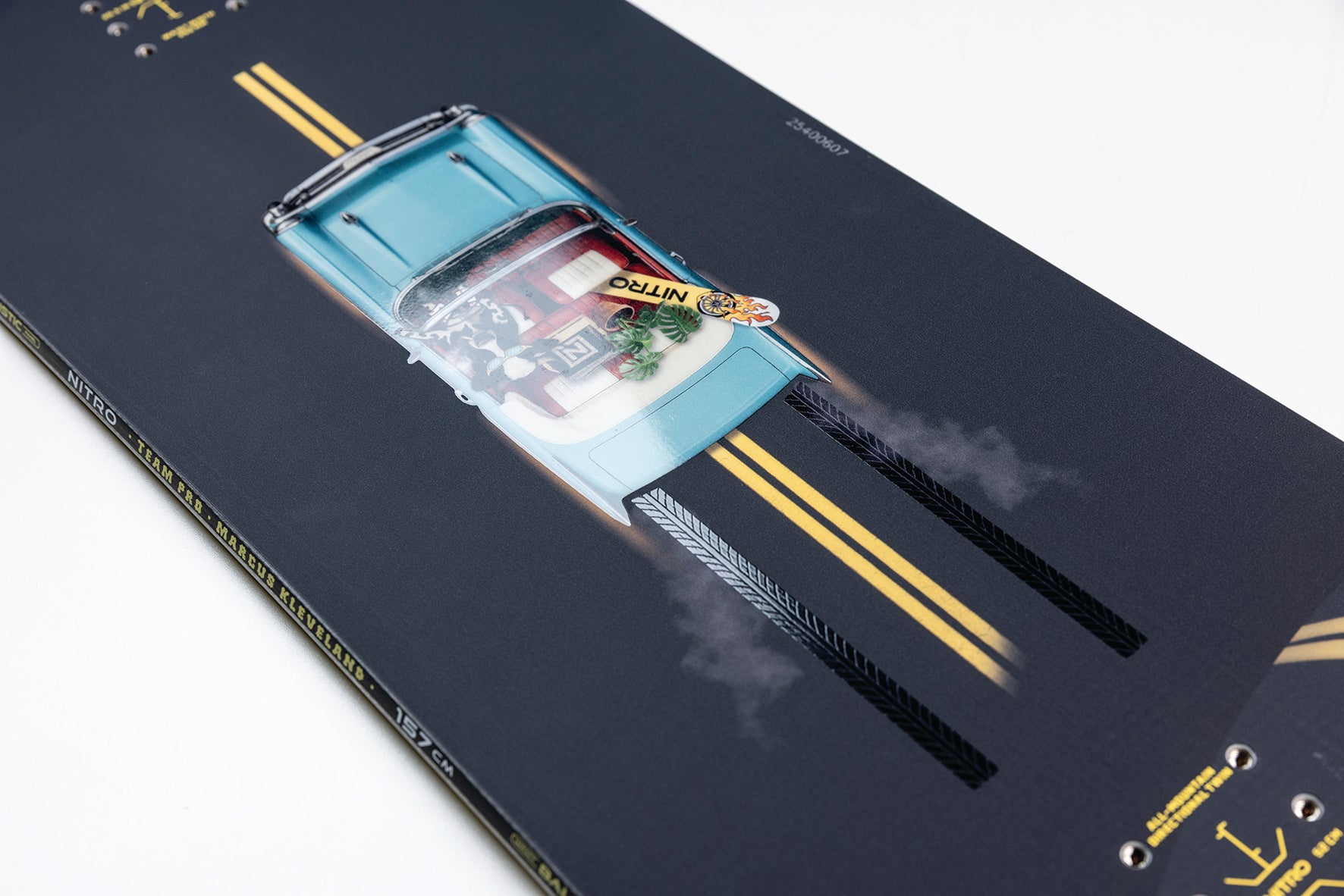 Close-up of Nitro Team Pro Marcus Kleveland snowboard with detailed graphics and branding, resting on snow.