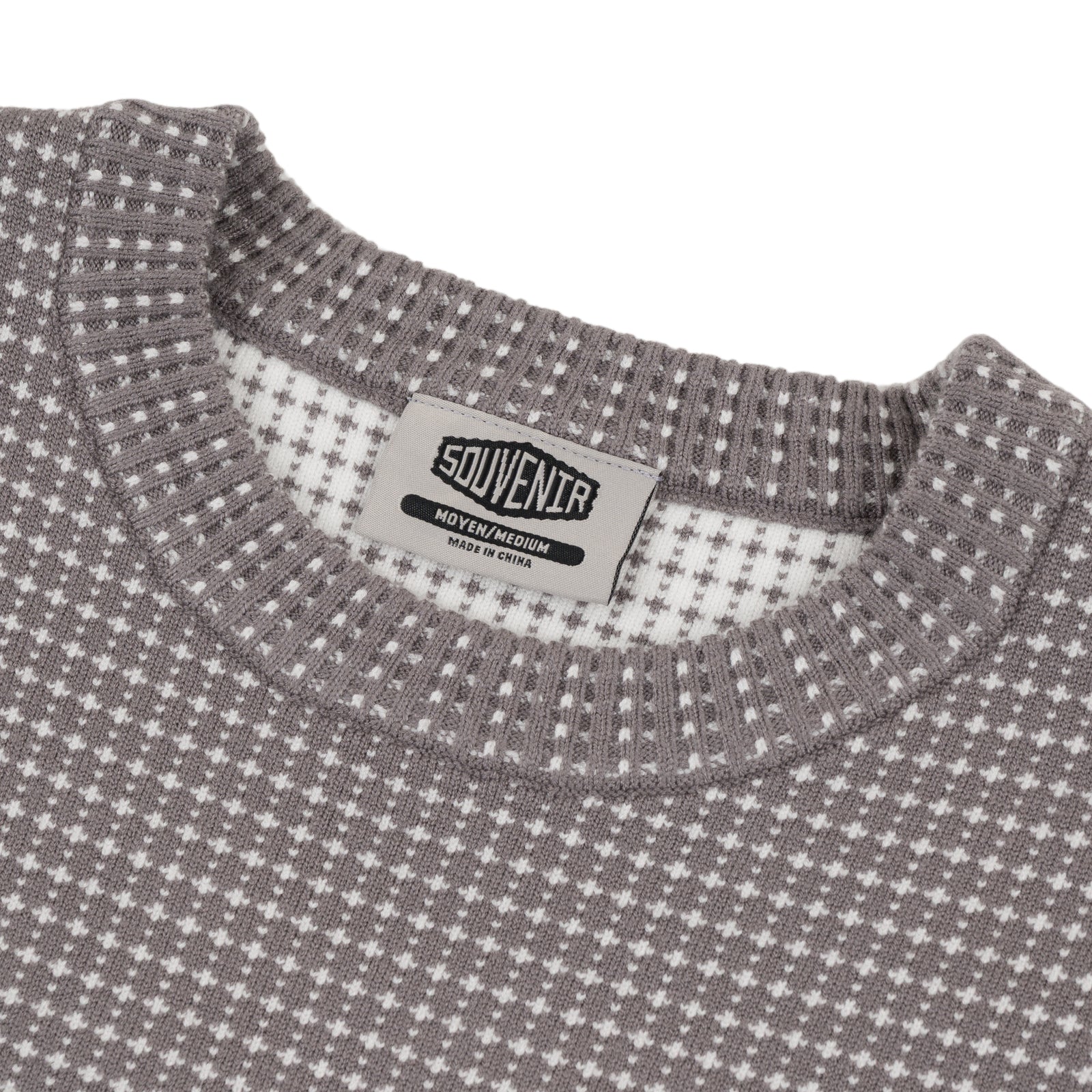 Close-up of Souvenir Jacquard Knit Sweater in cool grey, showing intricate knit pattern and textured fabric.