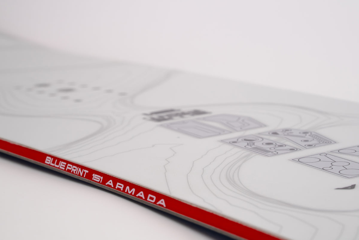 Side view of Armada Blueprint Snowboard 2027 showing its sidewall and design details on a snow surface.