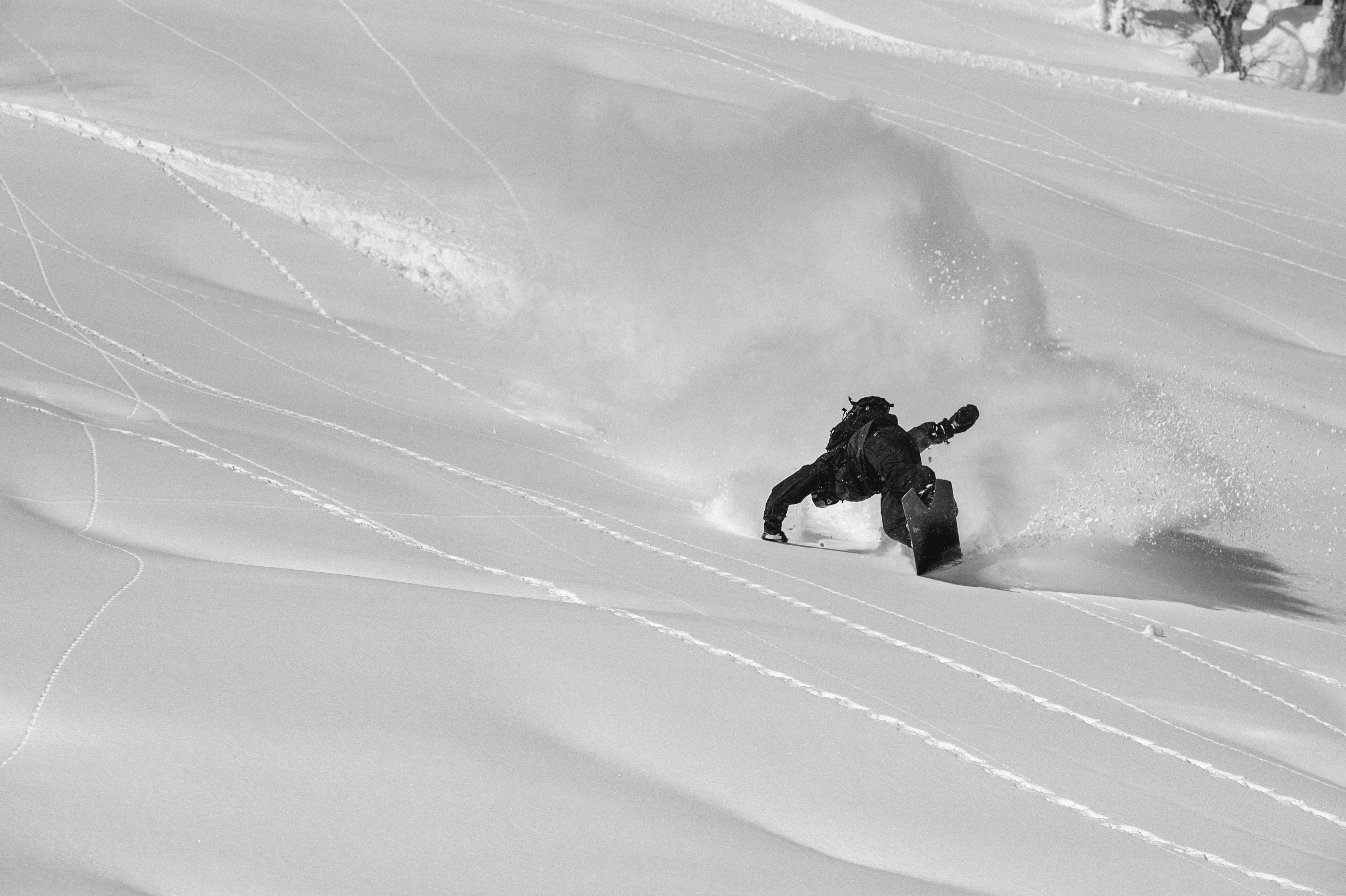 Korua Dart snowboard in snow, showcasing its design and shape for freestyle snowboarding.