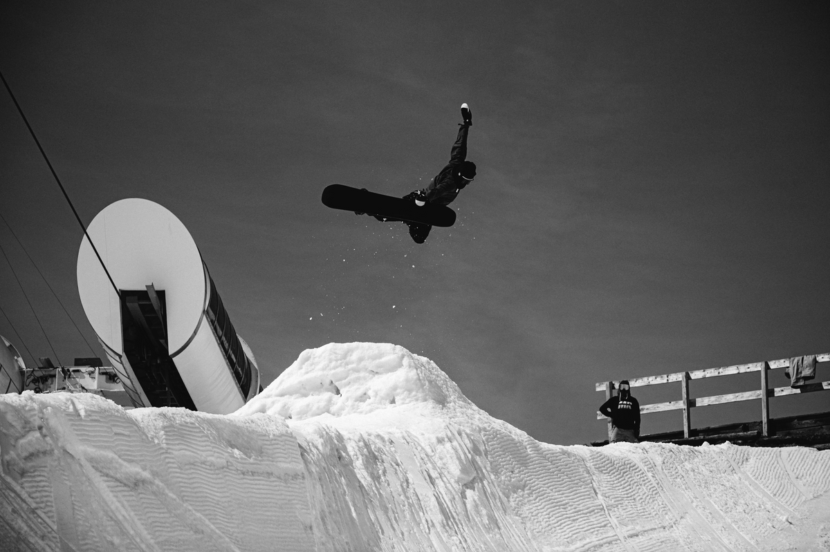 Korua Otto Plus snowboard on snow, showing the board's design and graphics in a natural outdoor winter setting