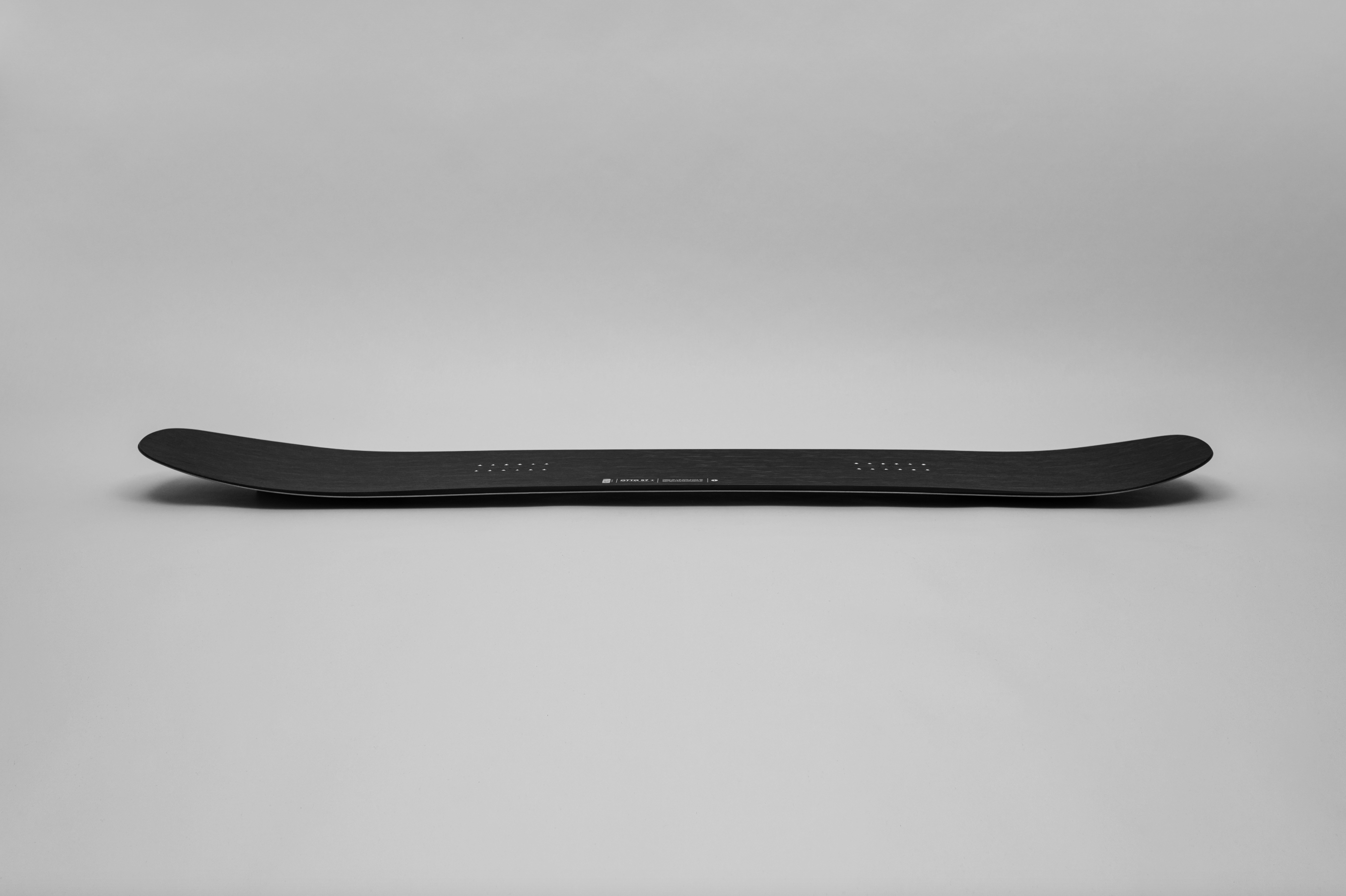 Korua Otto Plus snowboard with a side view, showcasing its design and construction for snowboarding performance.