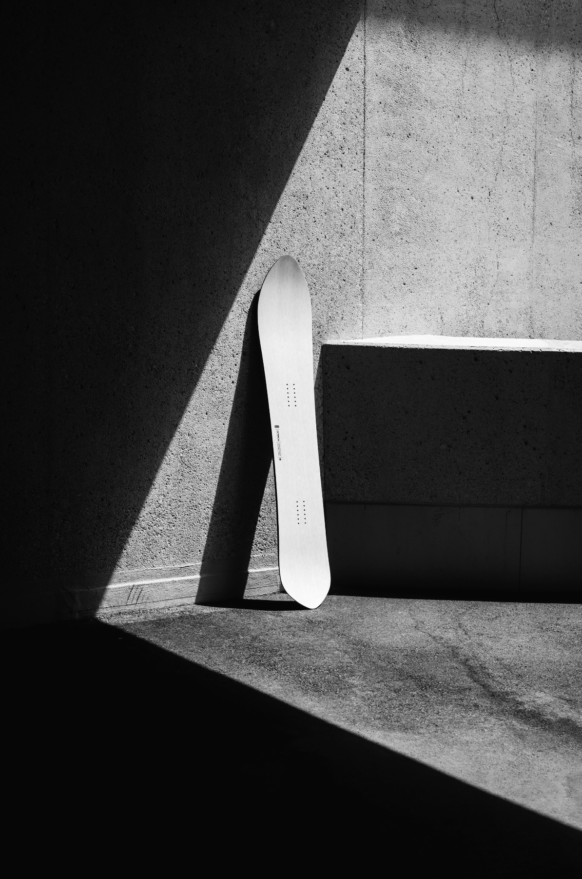 Korua Pin Tonic Snowboard outdoors on snow, showcasing the snowboard's design and graphics in a natural winter setting.