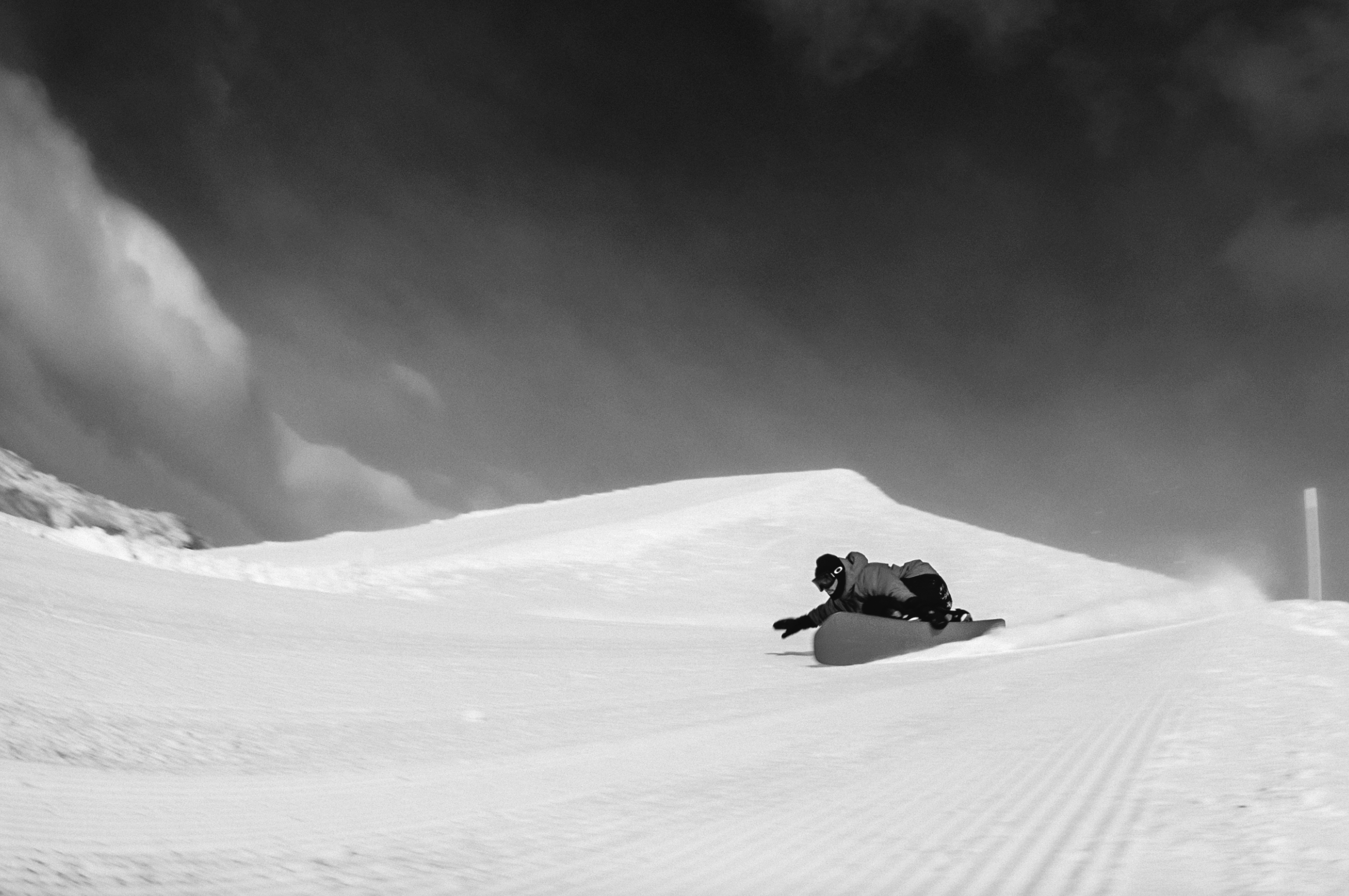 Korua Pocket Rocket snowboard with toeside edge on snow, showcasing its design and shape for freestyle snowboarding.