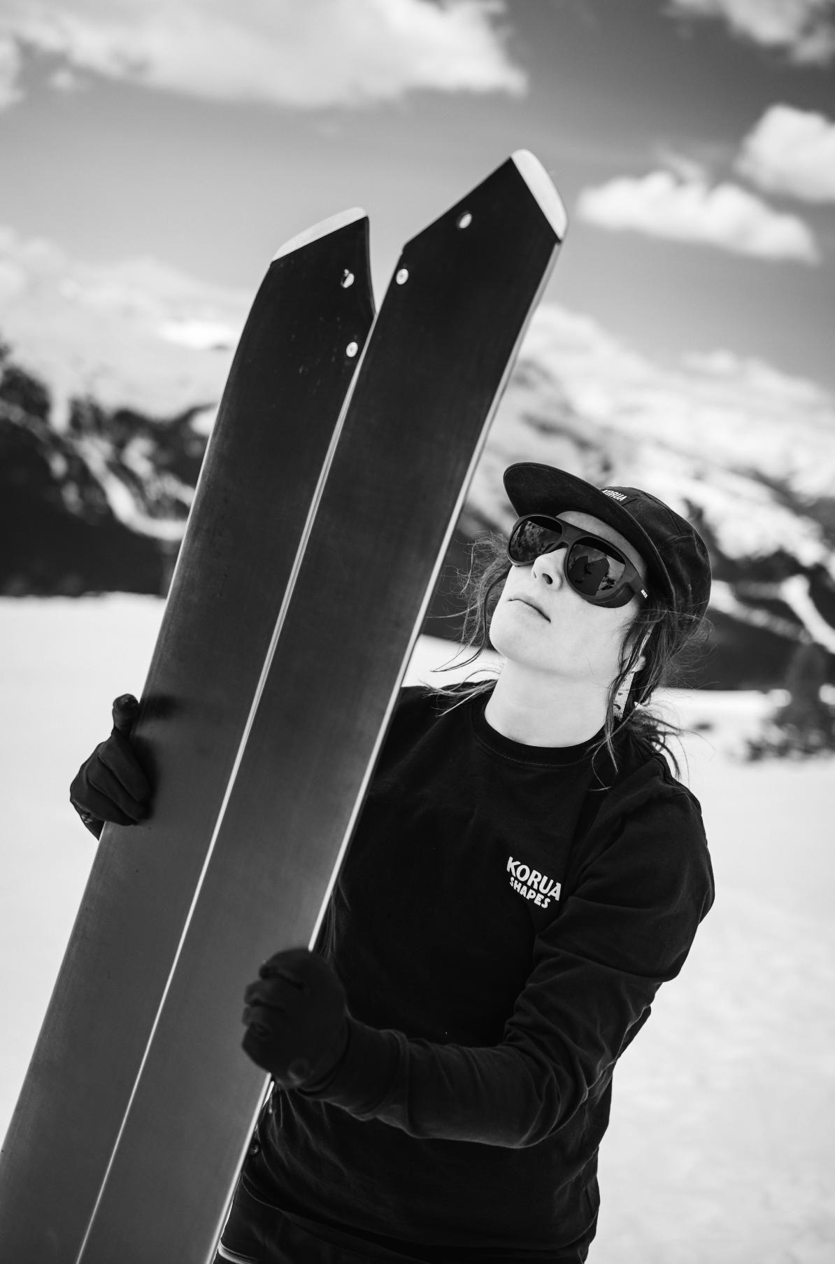 Korua Quill Split Snowboard resting on snow, showcasing its split design and graphics, ideal for backcountry snowboarding.