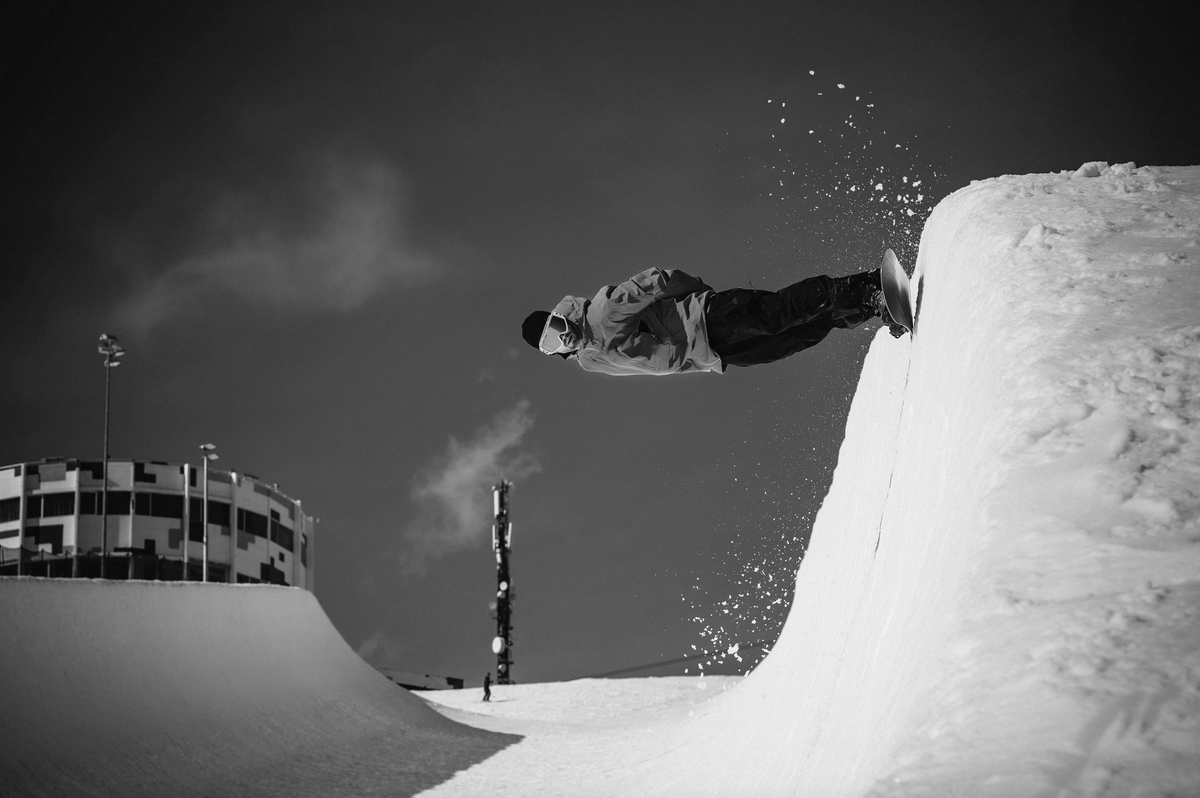 Korua Bullet Train Plus snowboard in snow, showcasing its shape and design for pipe carving and snowboarding performance.