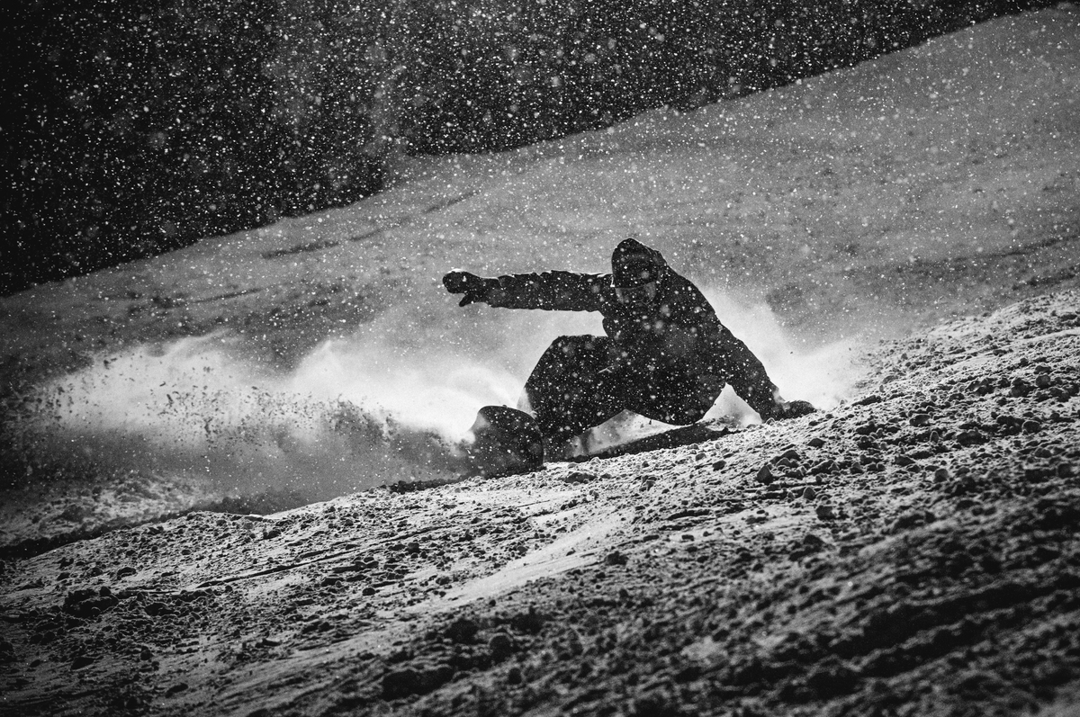 Korua Pencil Junior snowboard showing the heel side profile with detailed shape and graphics on a snow surface.