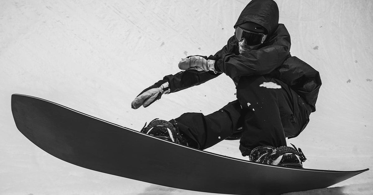 Korua Transition Finder snowboard heel side view on a snowy surface.