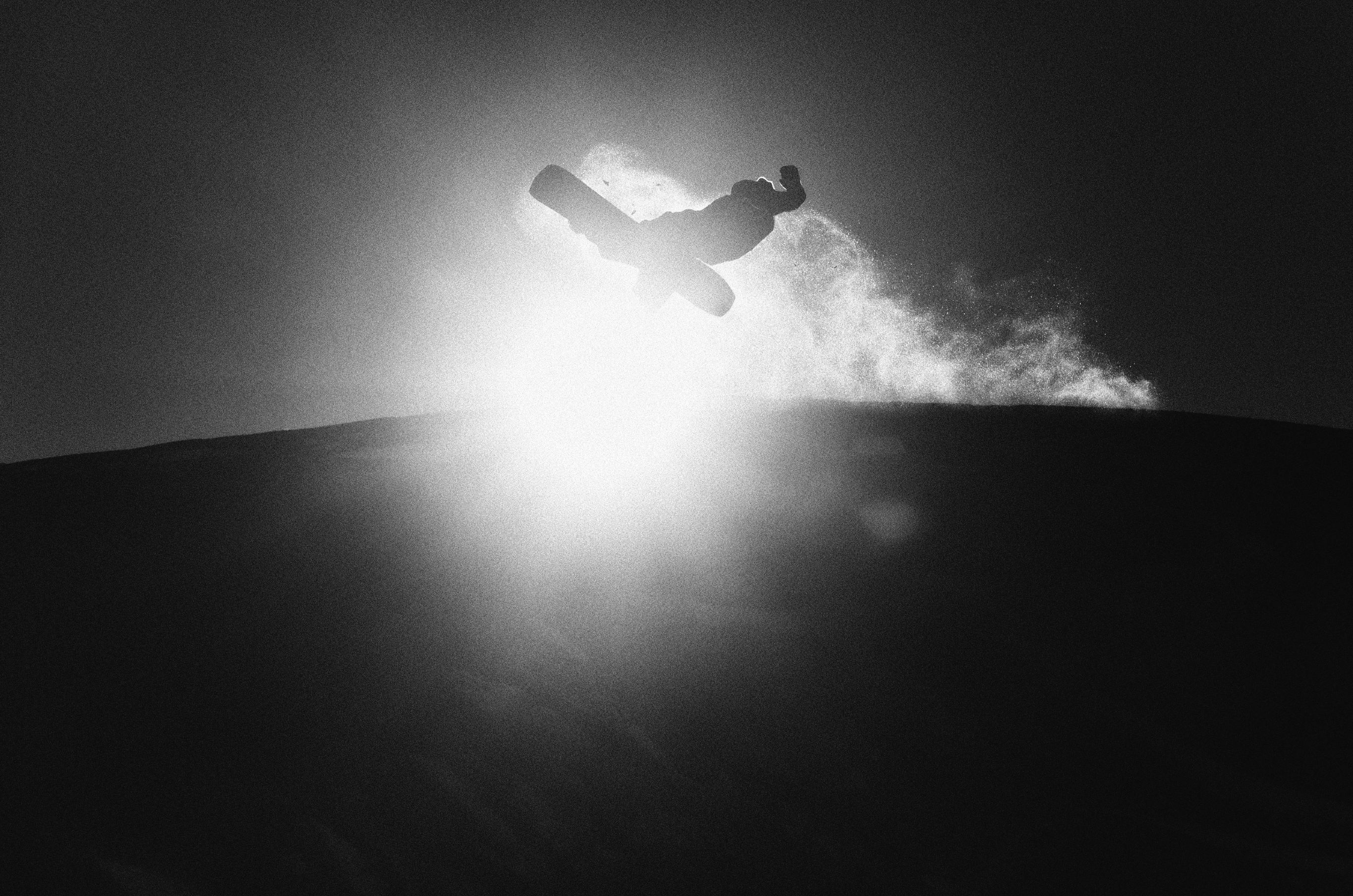 Korua Transition Finder snowboard on snow with a sun in the background