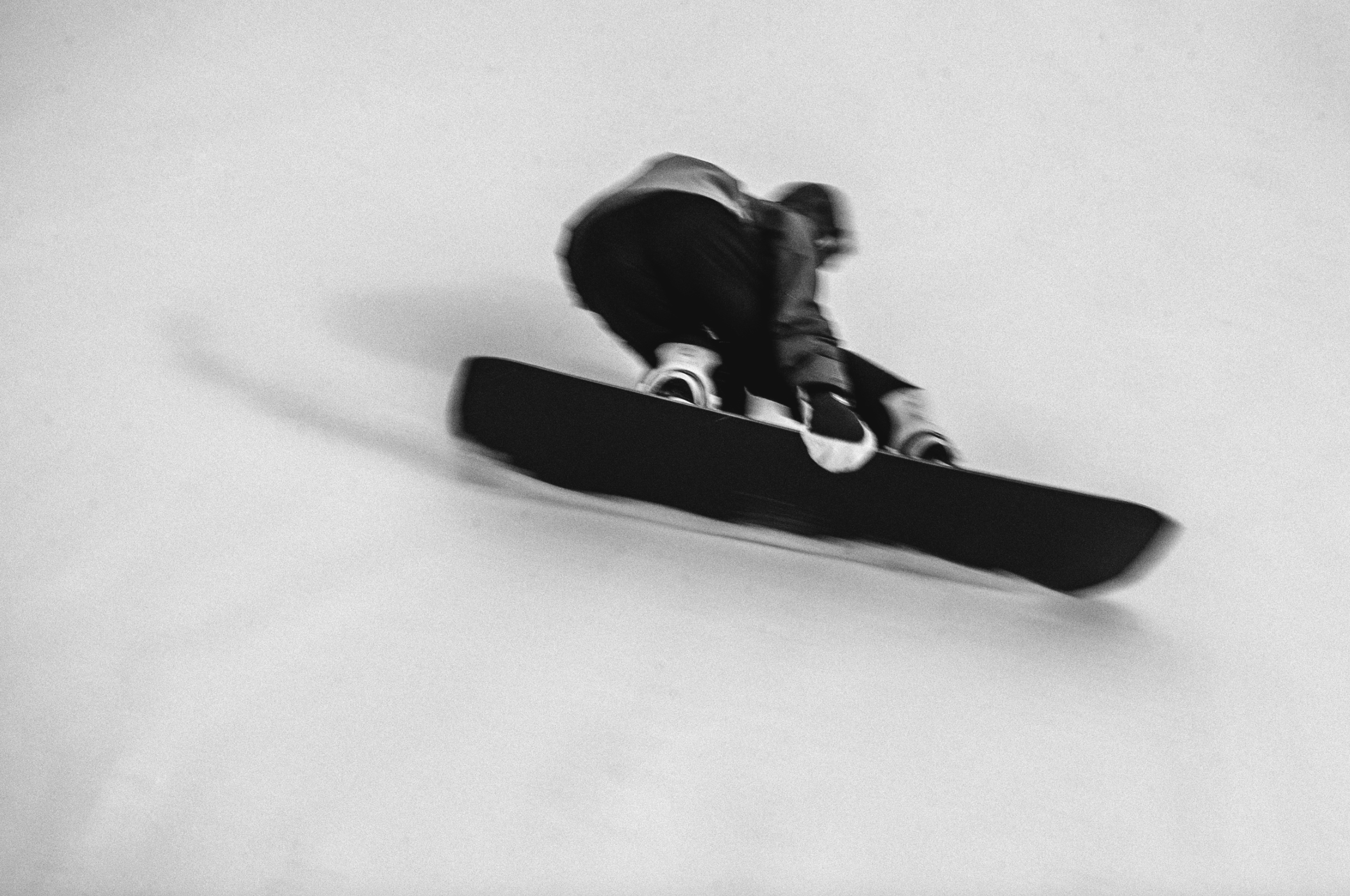Korua Transition Finder Plus snowboard showing a toeside grab in snow, highlighting the snowboard's design and snowy terrain.