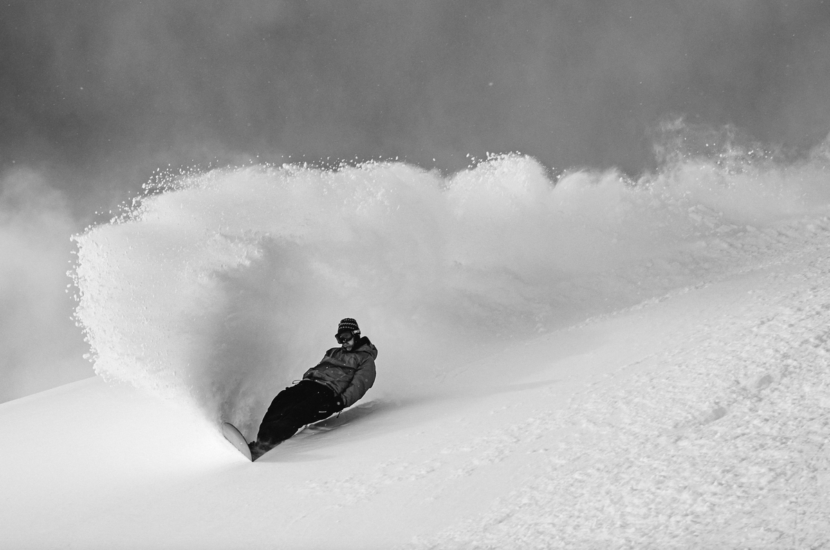 Korua Uberegg snowboard in snow with fresh powder and slash marks, showcasing the versatile all-mountain design by Korua.