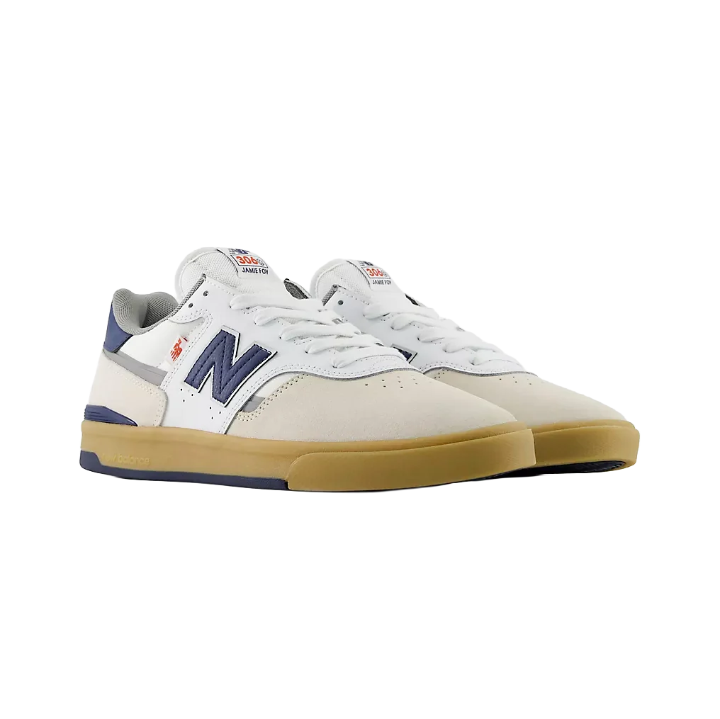 Pair of New Balance Numeric Jamie Foy 306 Cup skate shoes in white and blue shown from a front three-quarter angle with white laces, navy N logos and gum cupsoles.