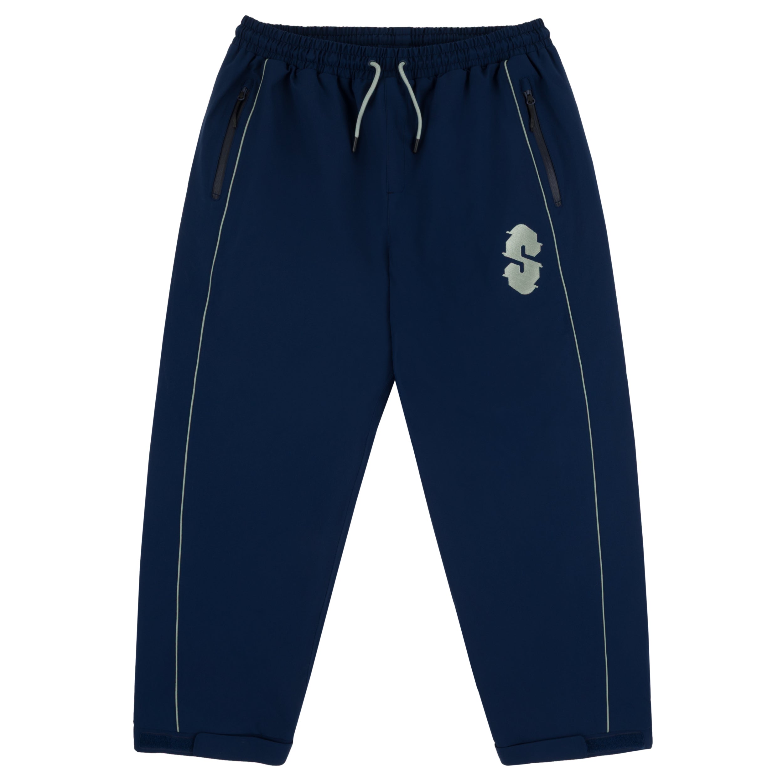 Souvenir Insulated Track Pant 2027 in Navy shown from the front with baggy track fit, elastic drawstring waist, zippered hand pockets, reflective piping and embroidered Souvenir thigh logo.