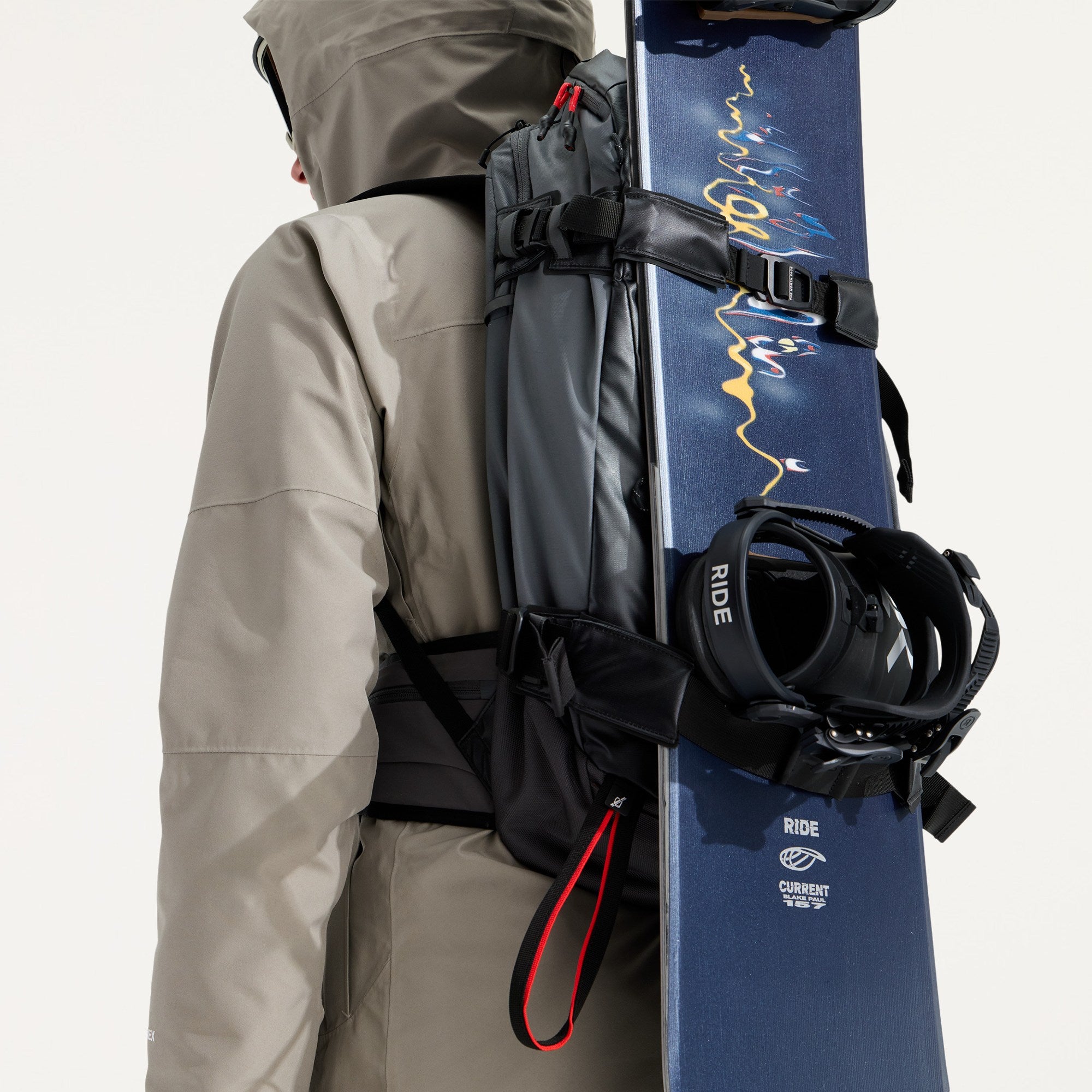 The North Face Slackpack 30 snow backpack worn with a snowboard secured vertically using the external board carry straps.