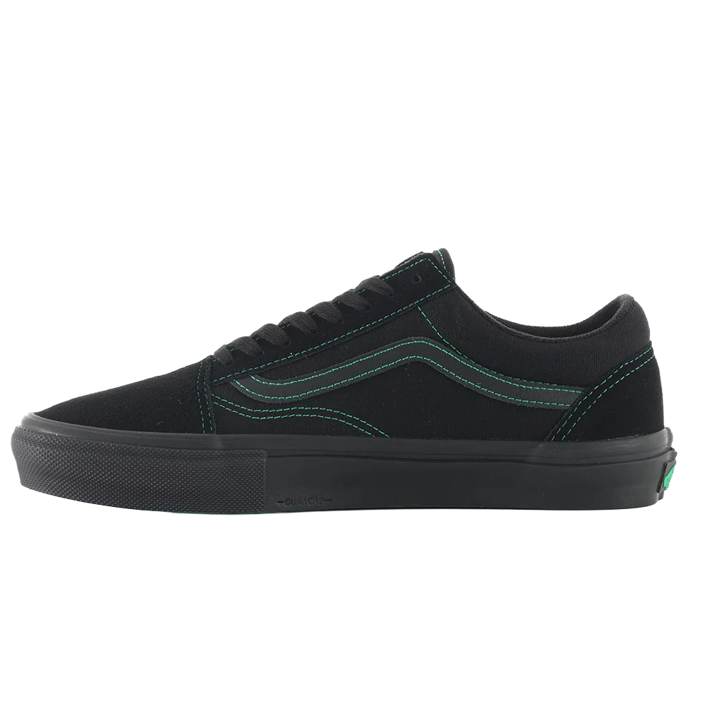 Inner side profile of the Vans Skate Old Skool in black with green contrast stitching and black vulcanized sole.