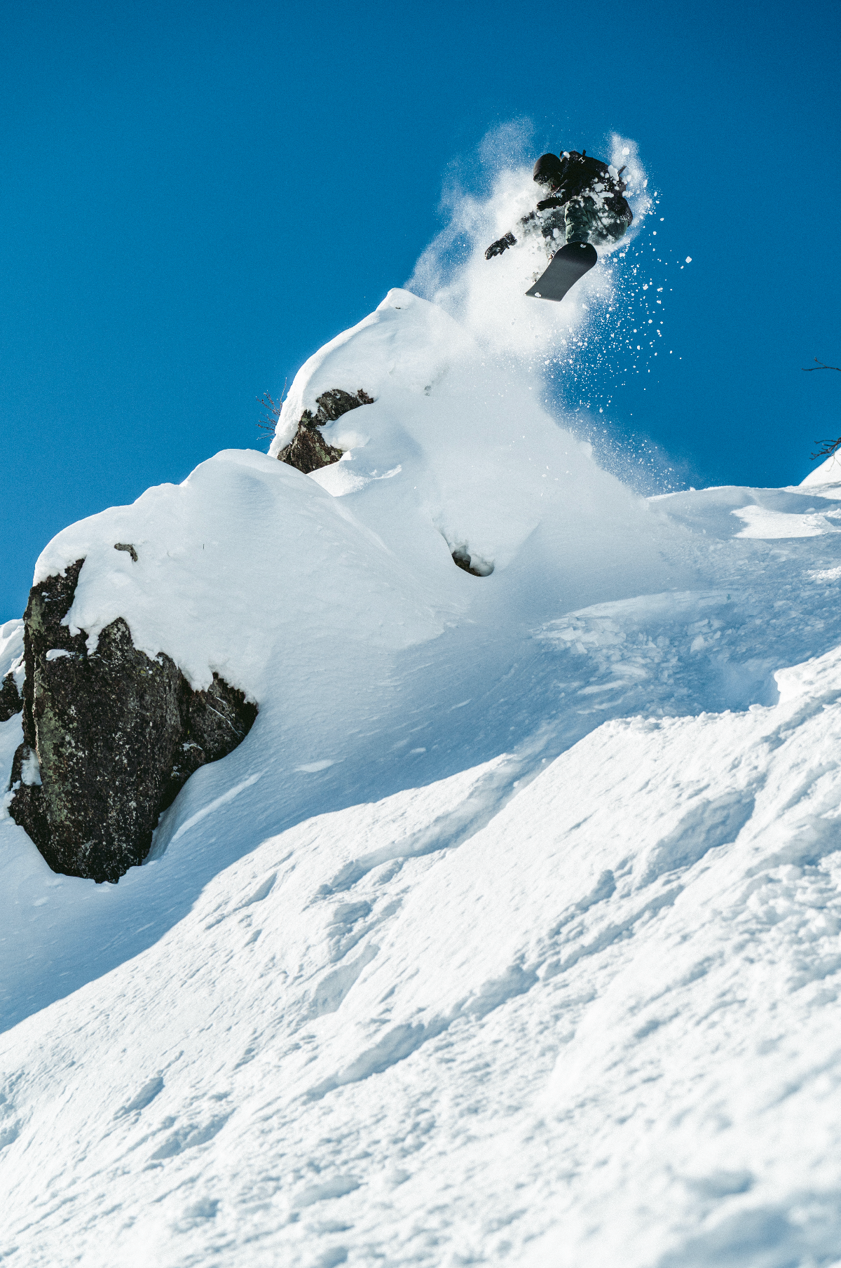 United Shapes Deep Reach snowboard in winter landscape, showcasing its design and shape for snowboarding adventures.