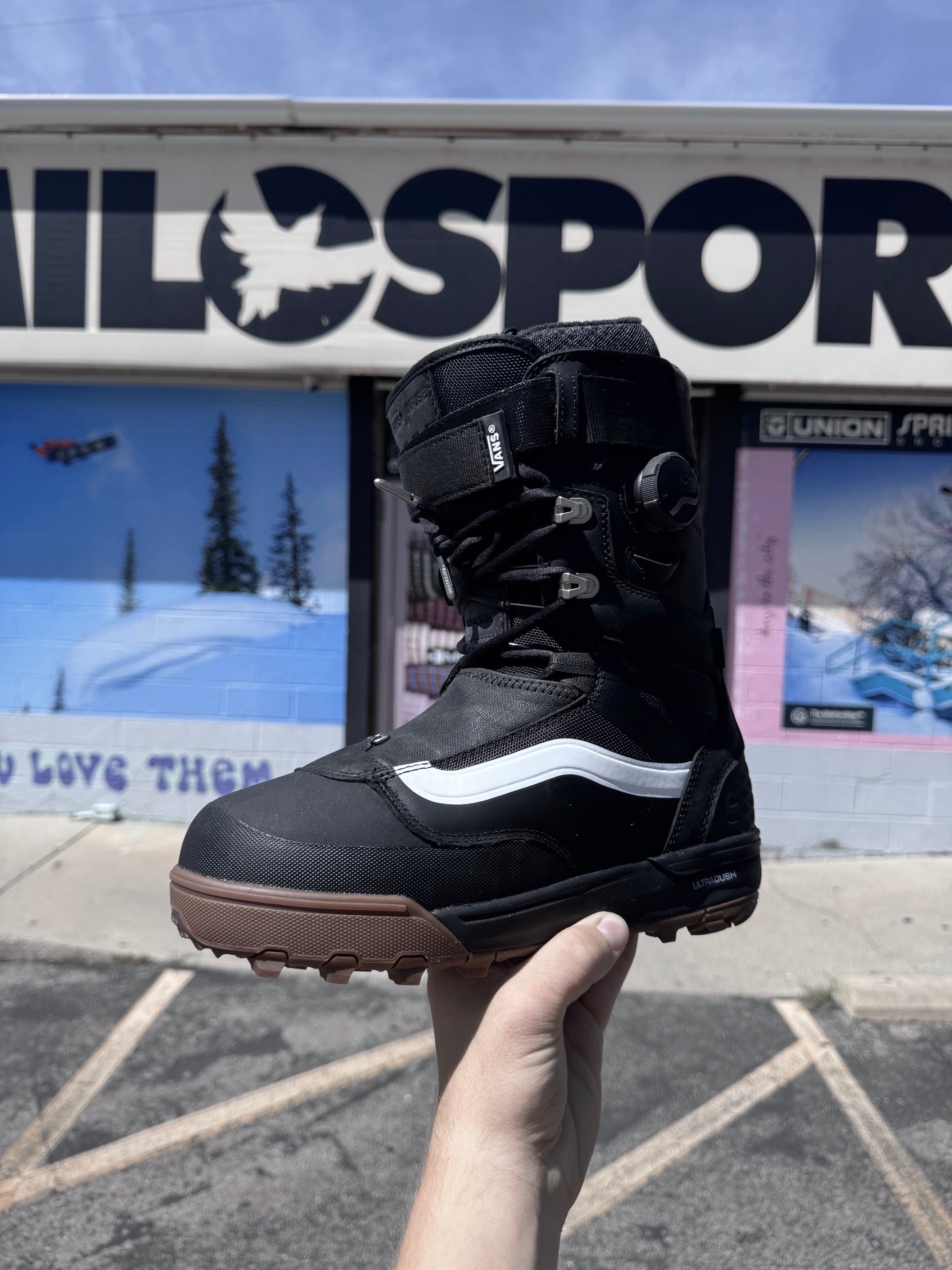 vans infuse snowboard boot at milosport in front of the store with the sign in the background