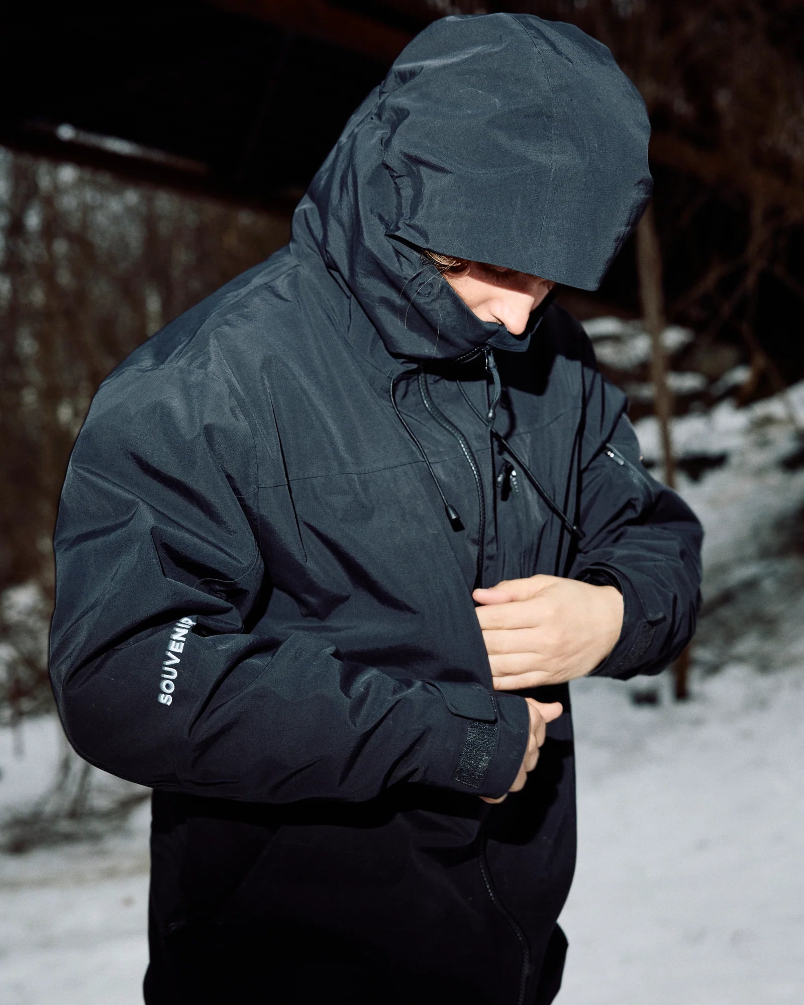 Mens Souvenir 3 Ply Shell Jacket in black with ripstop fabric, featuring a sleek design and adjustable hood.