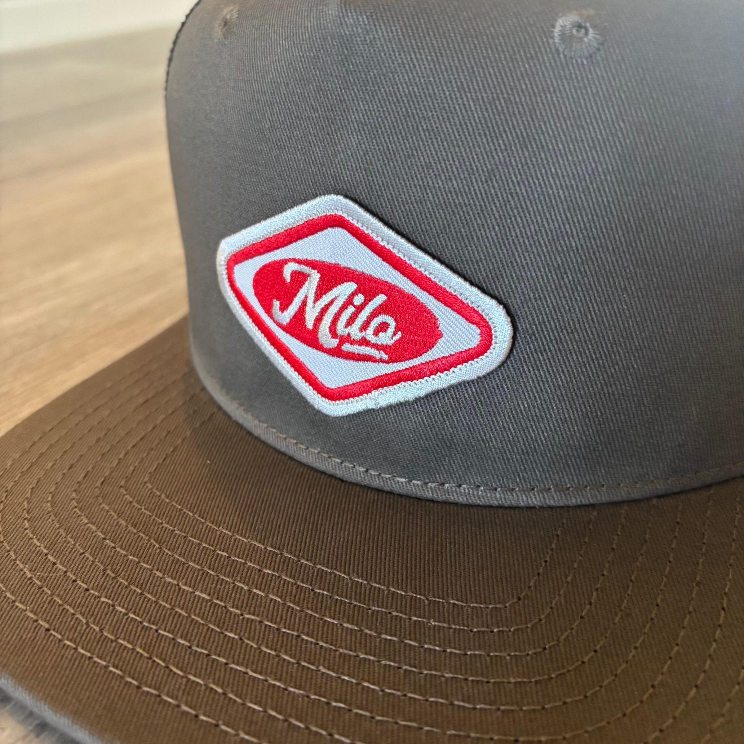 Milosport House Deli contrast trucker hat for men, featuring a structured design and adjustable snapback closure.