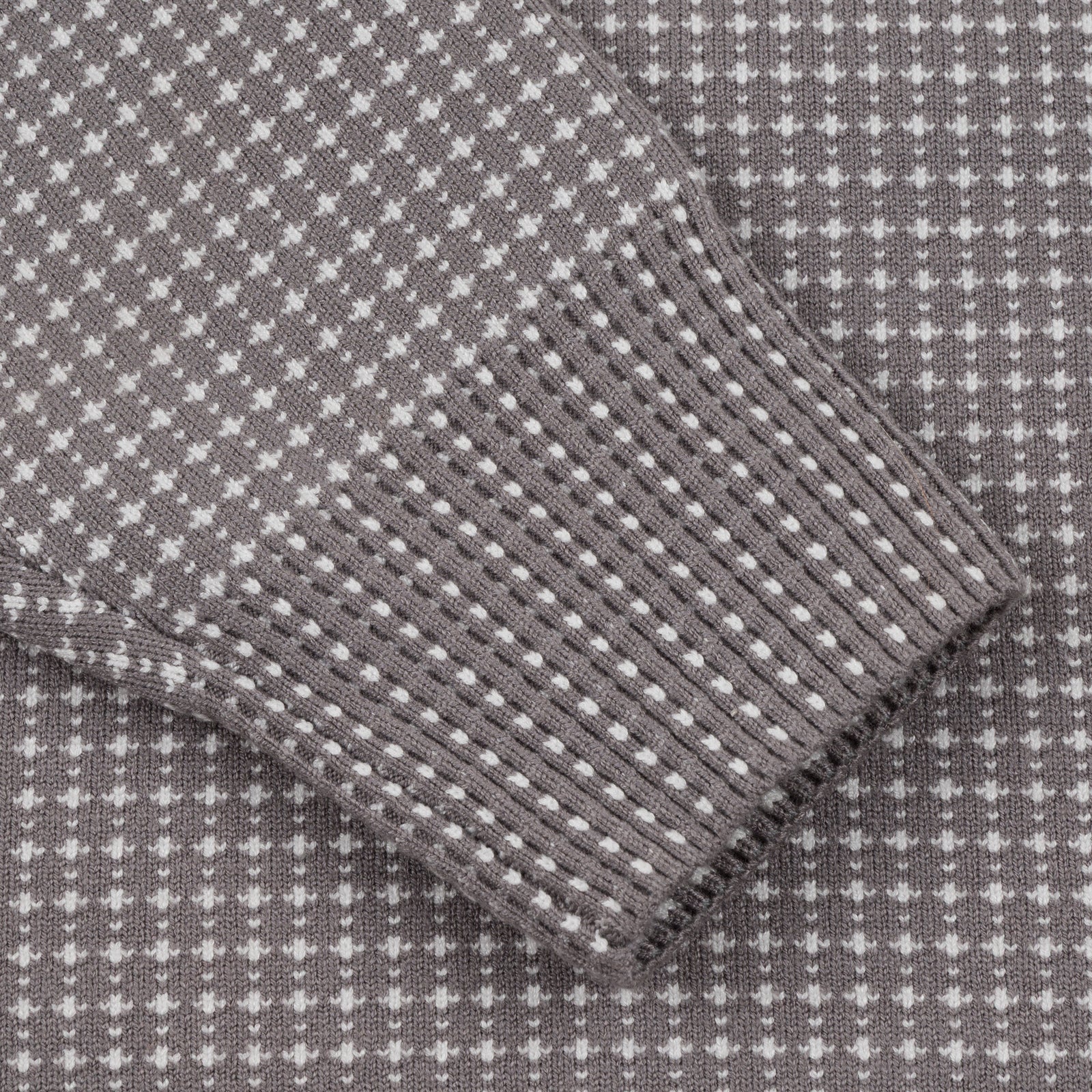 Close-up of Souvenir Jaquard Knit Sweater 2026 in cool grey, showing detailed jacquard pattern on the sleeve.
