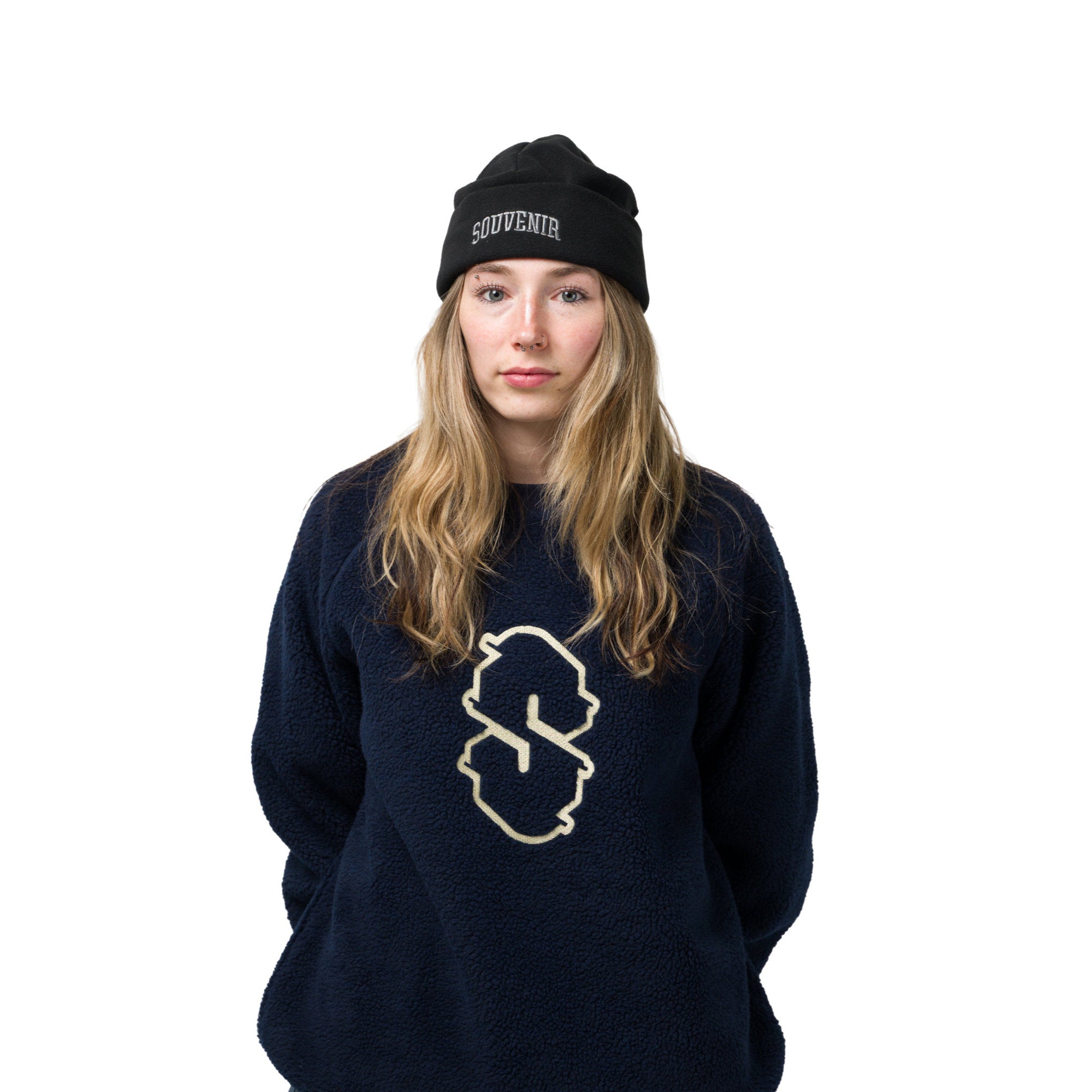 A girl wearing the Sherpa_Crew_Navy_Sweater at MILO with a black beanie and white background