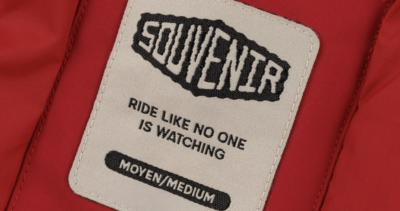 Label with text 'SOUVENIR' and 'Ride like no one is watching' on a red background