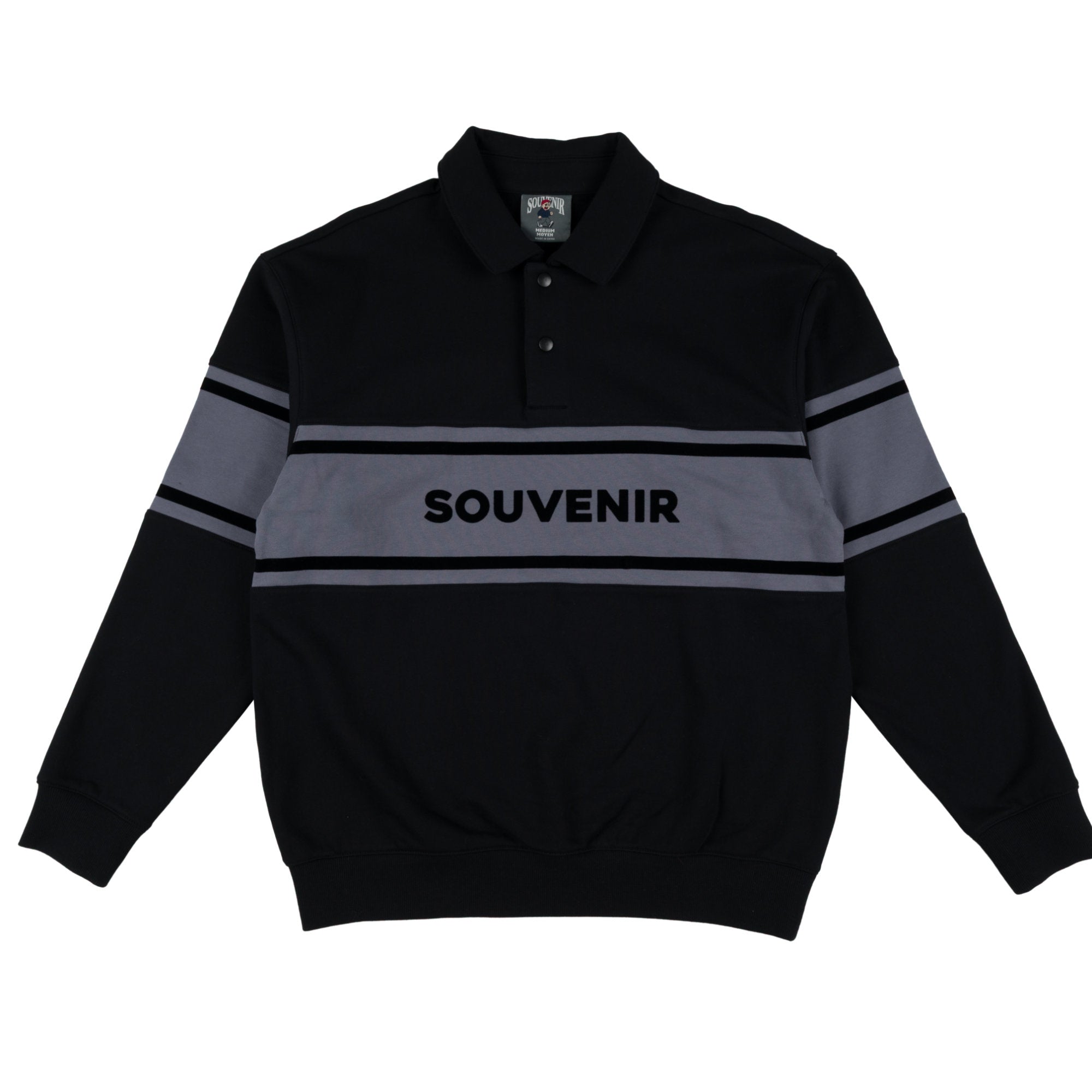A black long sleeve rugby style polo shirt with a gray chest stripe and 'SOUVENIR' printed across the center, displayed flat against a white background.