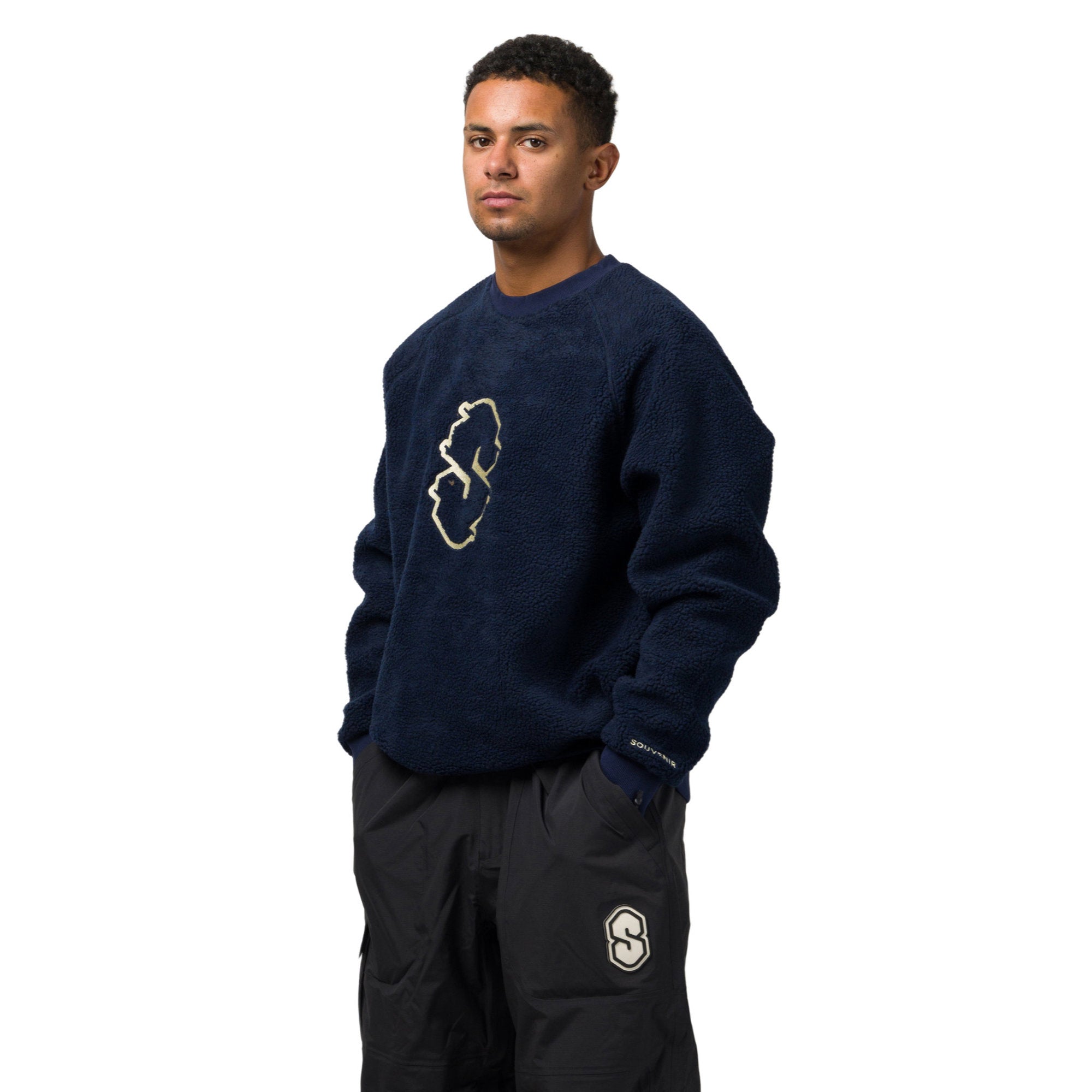 a shredder wearing the Souvenir Sherpa_Crew_Navy_SIDE view at milosport with a white background