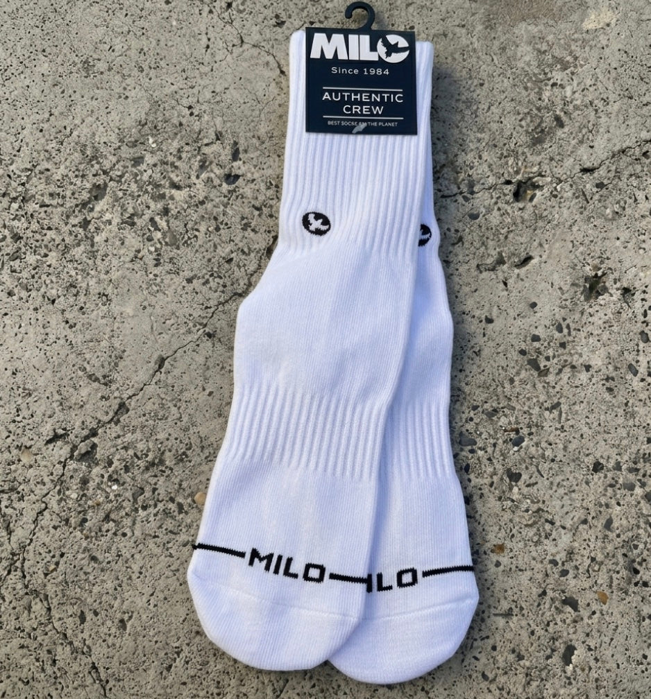 White socks with black branding on a concrete surface