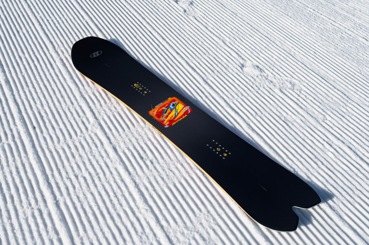Armada Shatter Point snowboard with detailed topsheet design, showcasing its sleek graphics and durable construction for snowboarding.