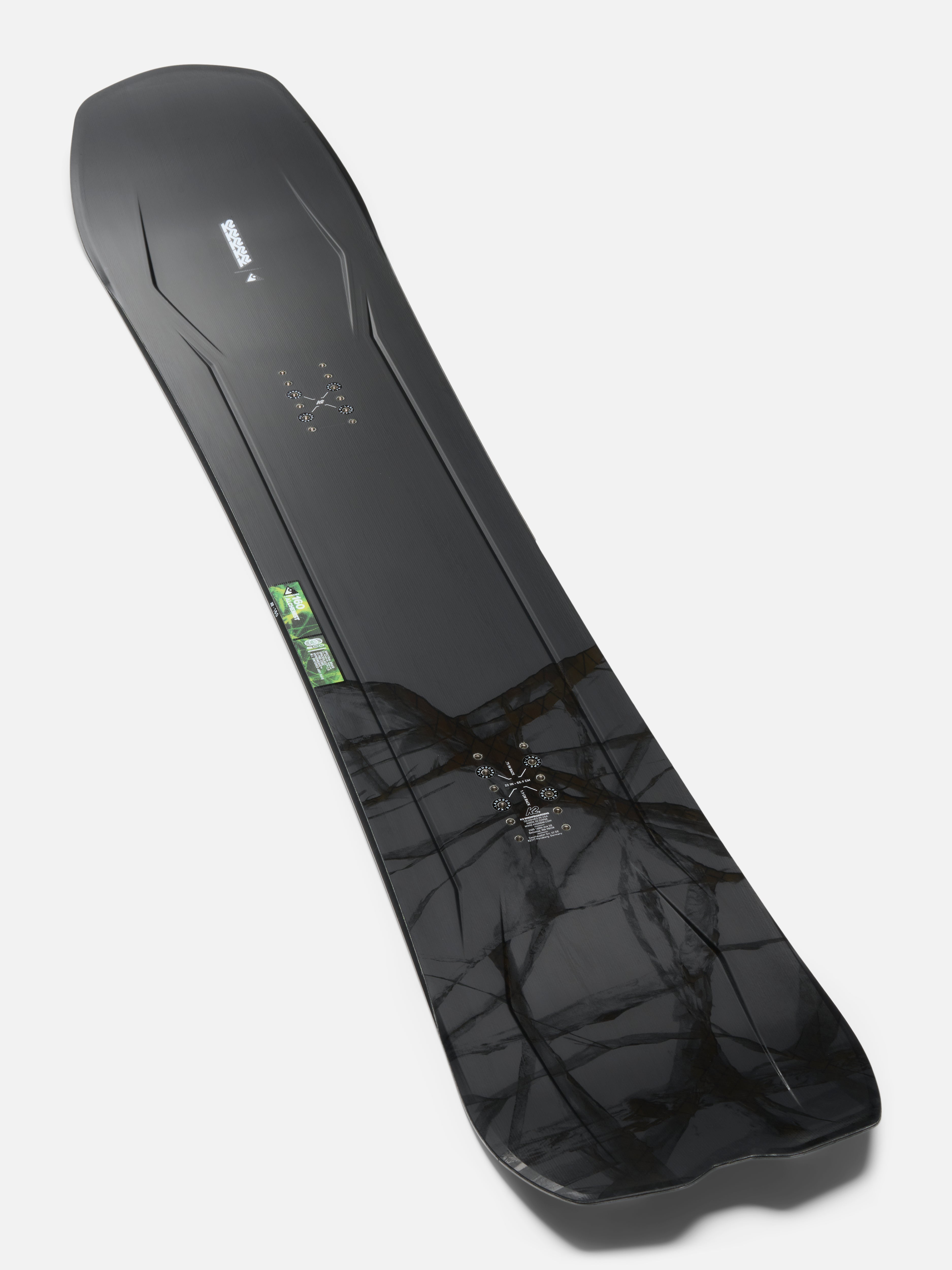 K2 Alchemist snowboard with intricate topsheet design, ready for snowboarding in winter conditions.