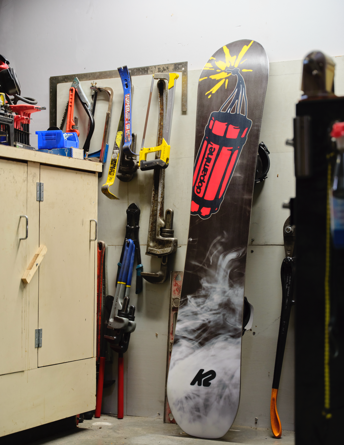 K2 Antidote snowboard 2027 with blue base and graphic design, designed for all-mountain snowboarding, shown on workshop surface.