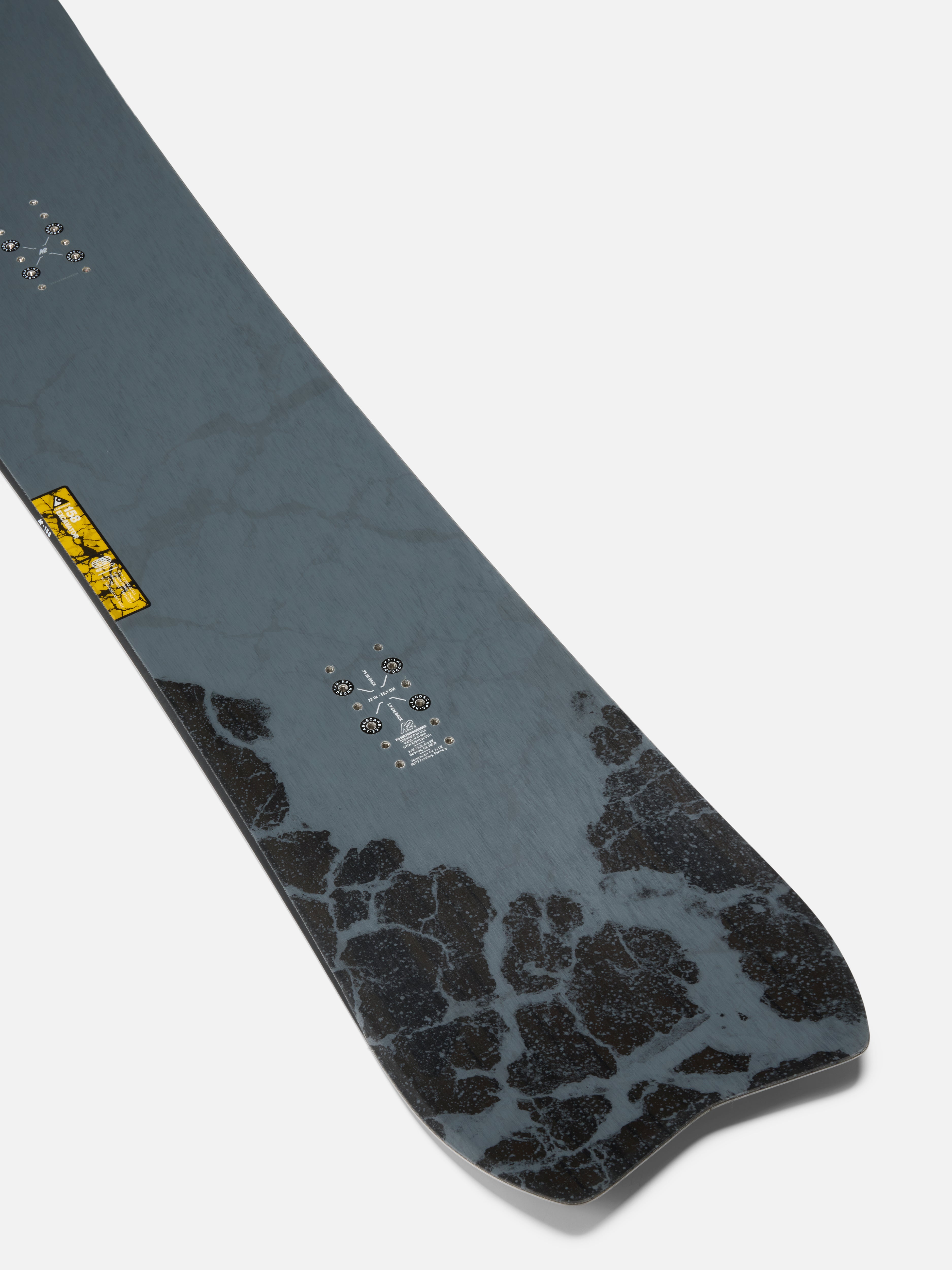 K2 Excavator Snowboard 2027 showing the tail design with a snowy background, highlighting the snowboard's shape and graphics.