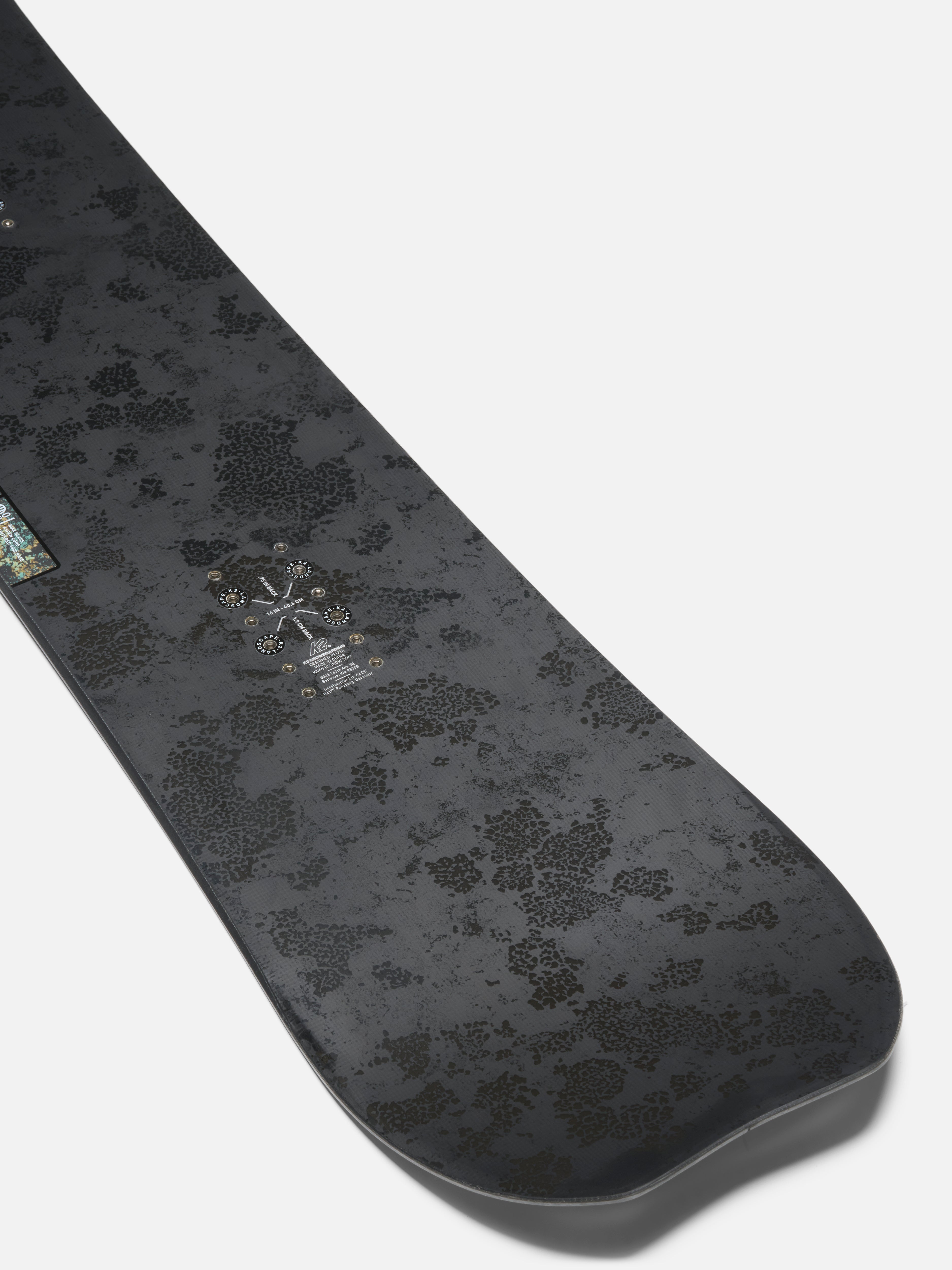 K2 Passport Jr snowboard for kids, showing the tail design with colorful graphics on a snow-covered landscape.