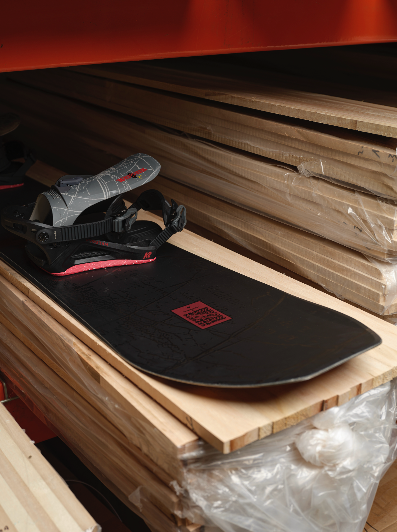 K2 Sky Pilot Snowboard 2027 with wooden nose design, displayed on a shelf, showcasing its top and side view.