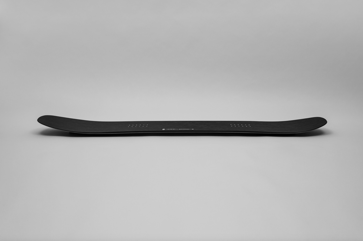 Korua Otto Plus snowboard with a side view, showcasing its design and construction for snowboarding performance.