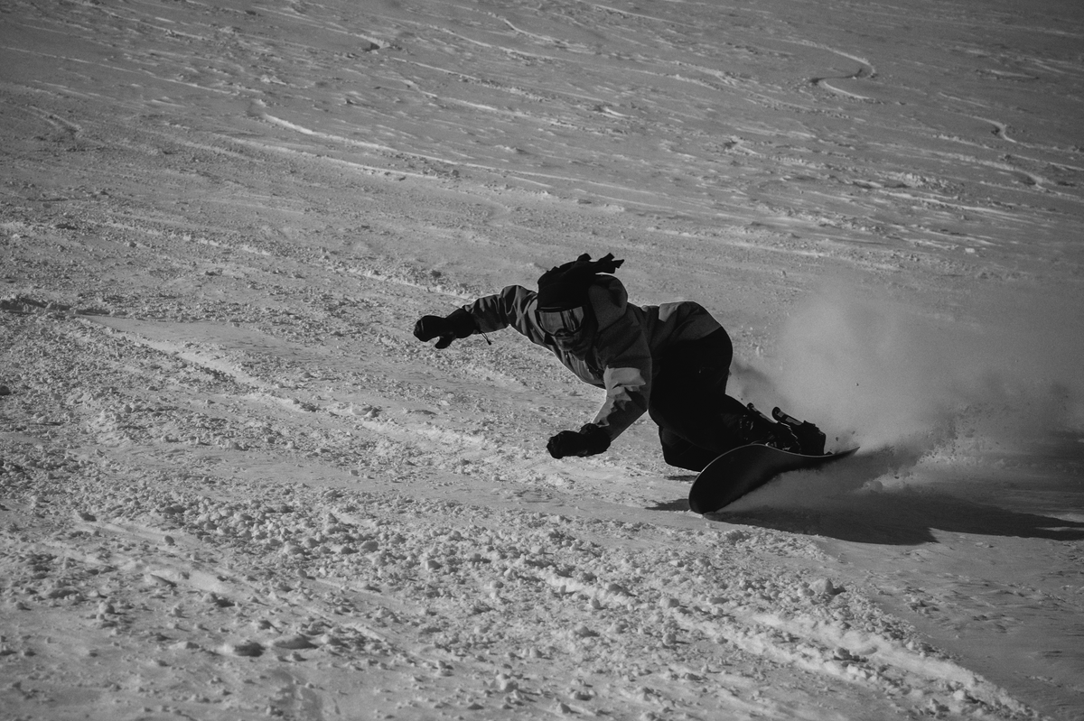 Korua Bullet Train Plus snowboard in snow, showing the toeside shape and design, ideal for all-mountain snowboarding.