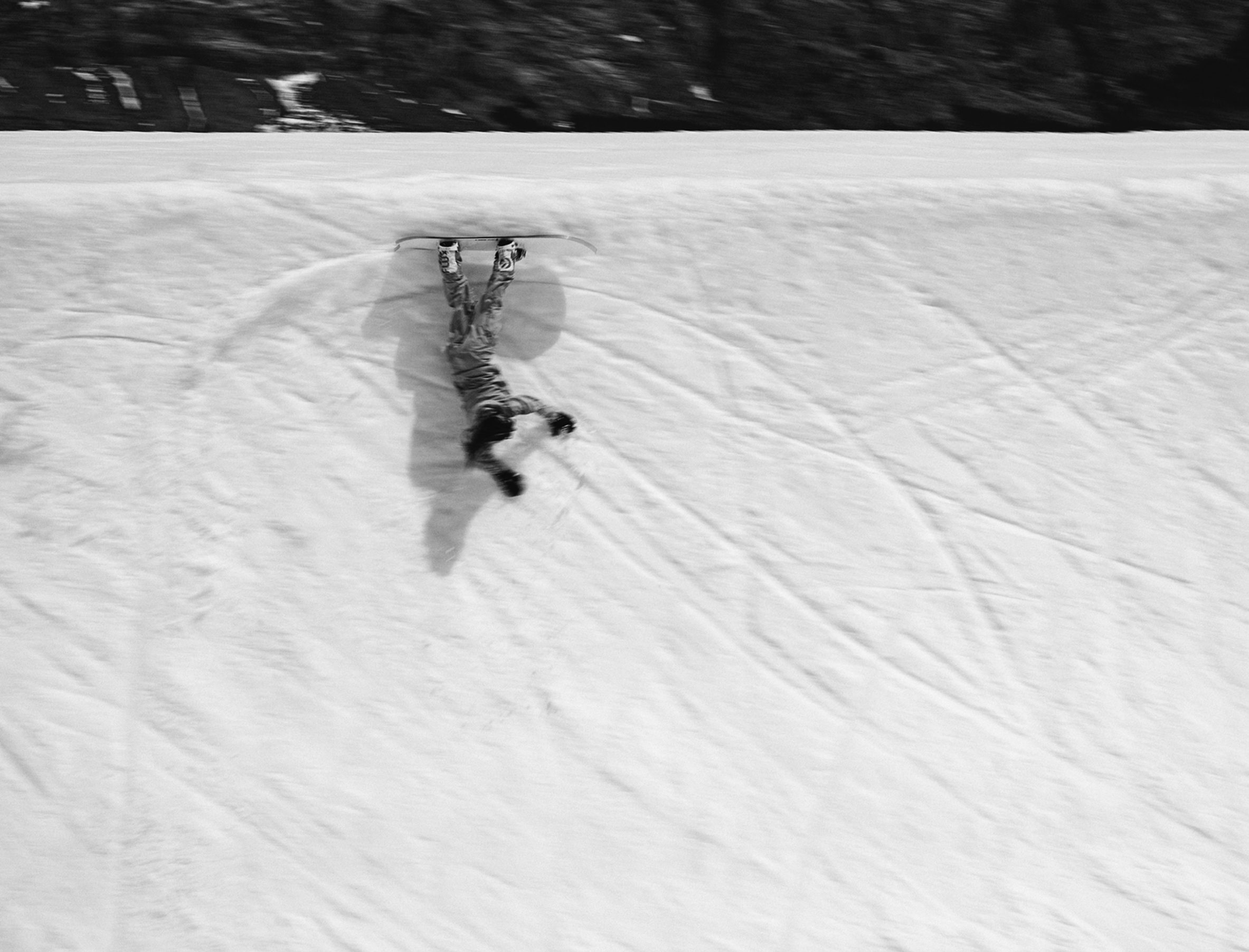 Korua Pencil snowboard with classic shape, displayed on snow, showcasing its tapered tips and sleek design for winter sports.