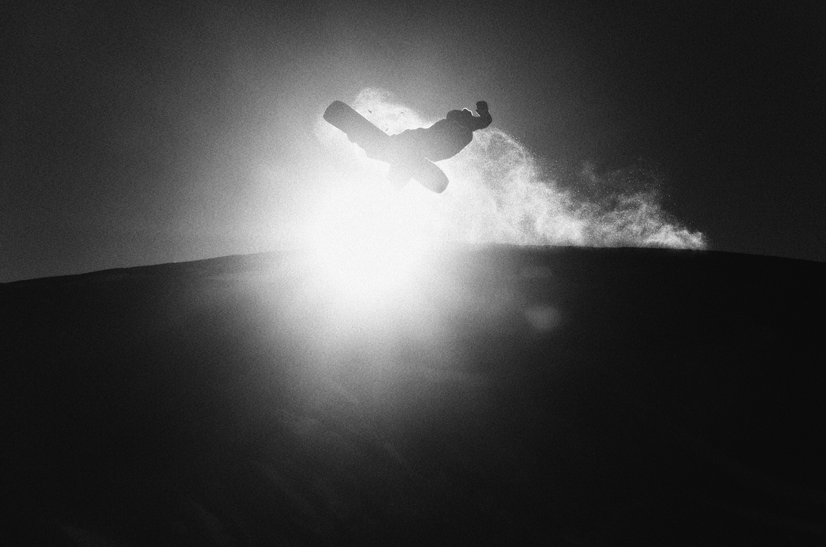 Korua Transition Finder snowboard on snow with a sun in the background