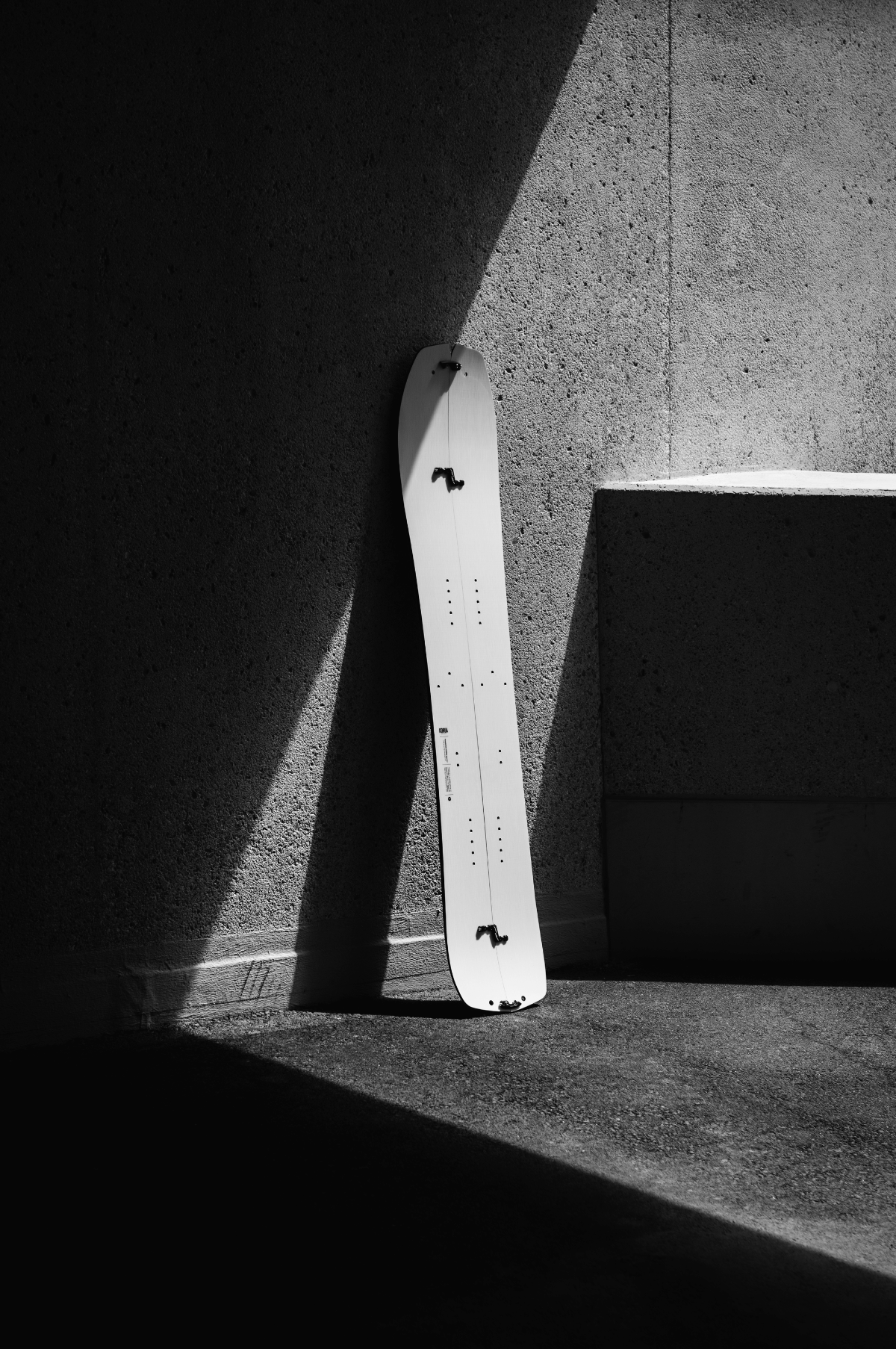 Korua Transition Finder split snowboard outdoors on snow, showcasing its design and construction in a natural mountain setting.