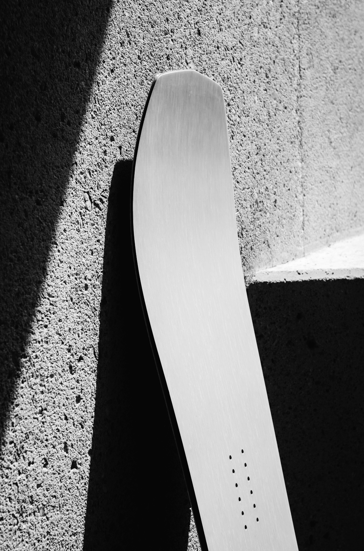 Korua Transition Finder snowboard with a cement background
