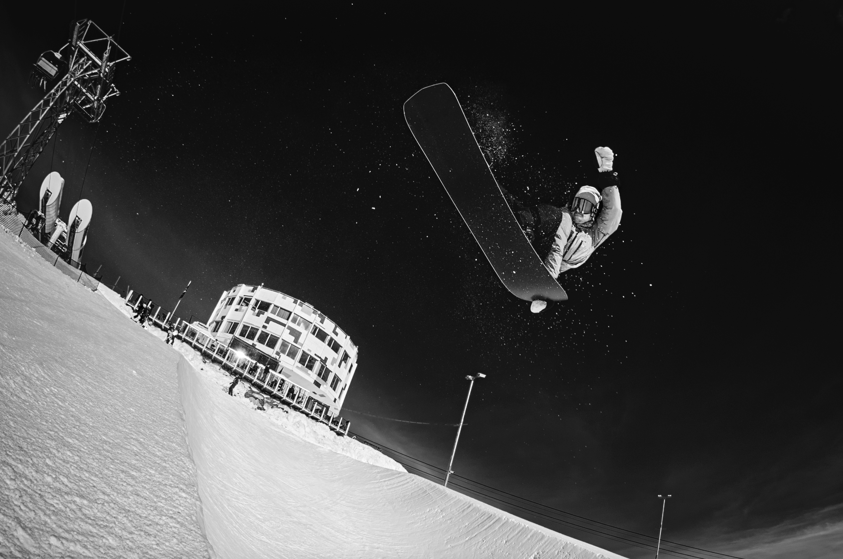 Korua Transition Finder Plus snowboard in snow, showing the board's design and graphics on a snowy surface.