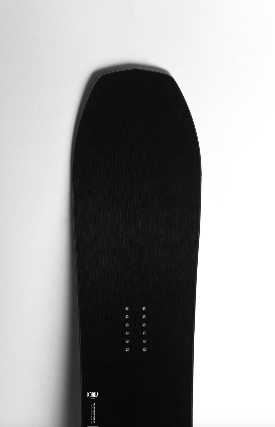 Korua Transition Finder Plus snowboard with a sleek design, featuring a pointed nose and vibrant graphics for winter snowboarding.