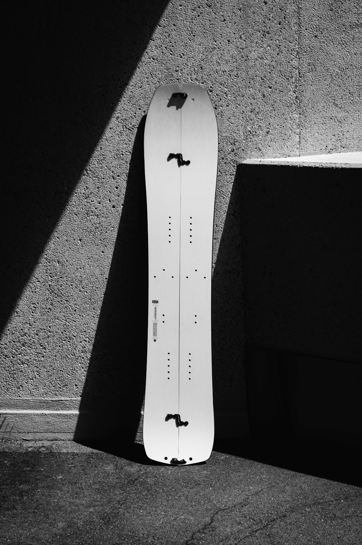 Korua Transition Finder split snowboard outdoors on snow, showcasing its design and splitboard features for snowboarding adventures.
