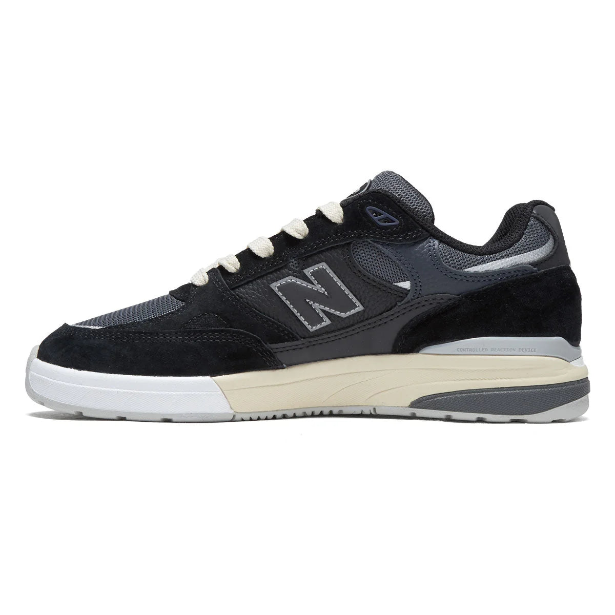 Inner side profile of the New Balance Numeric 933 Andrew Reynolds skate shoe in black and navy with layered suede and mesh upper and white cupsole.