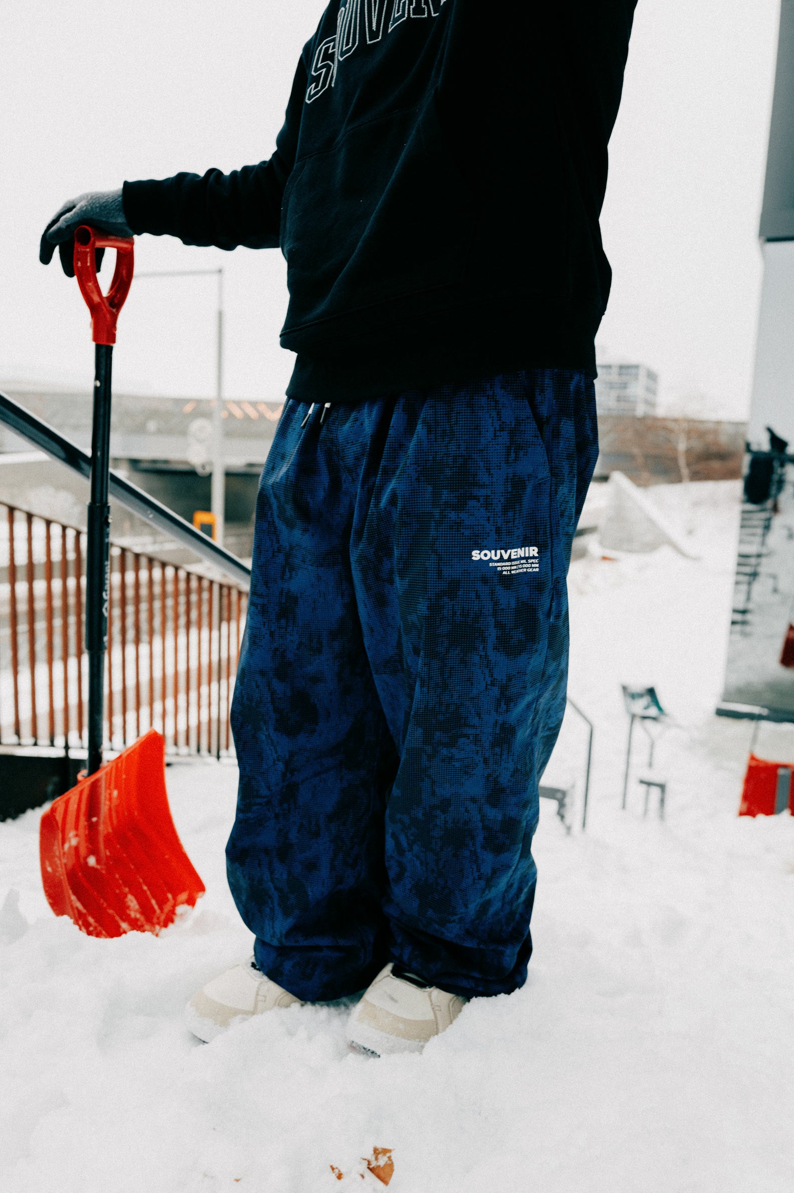 Full-length view of the Souvenir Parachute Pant 2027 in Petrol Blue Blotch Print showing the oversized leg shape and Souvenir thigh logo.
