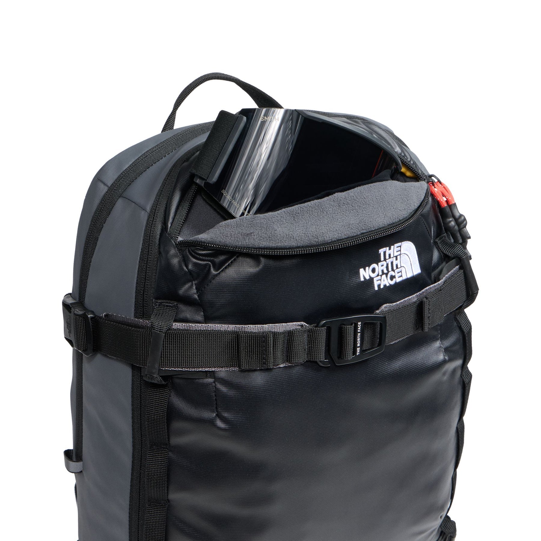 Open fleece-lined goggle pocket on The North Face Snowdrift 22 + 6 snow backpack with snow goggles stored inside.