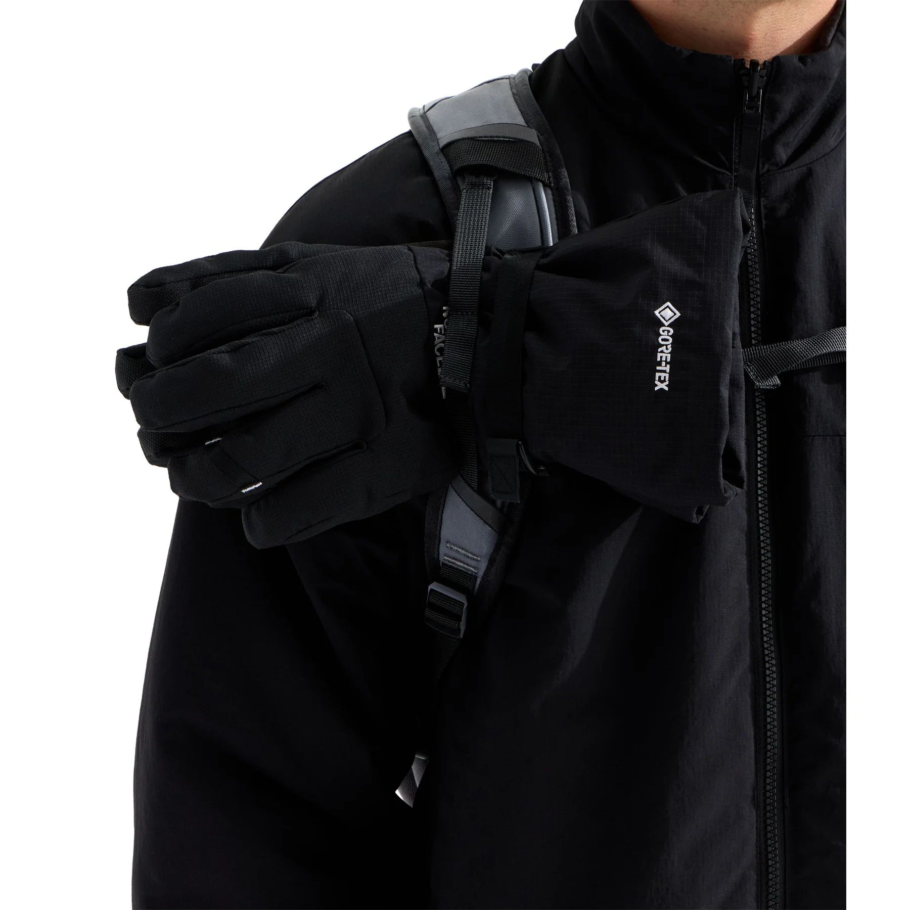 Close-up of The North Face Snowdrift 22 + 6 shoulder strap with gloves secured to the external gear attachment strap.