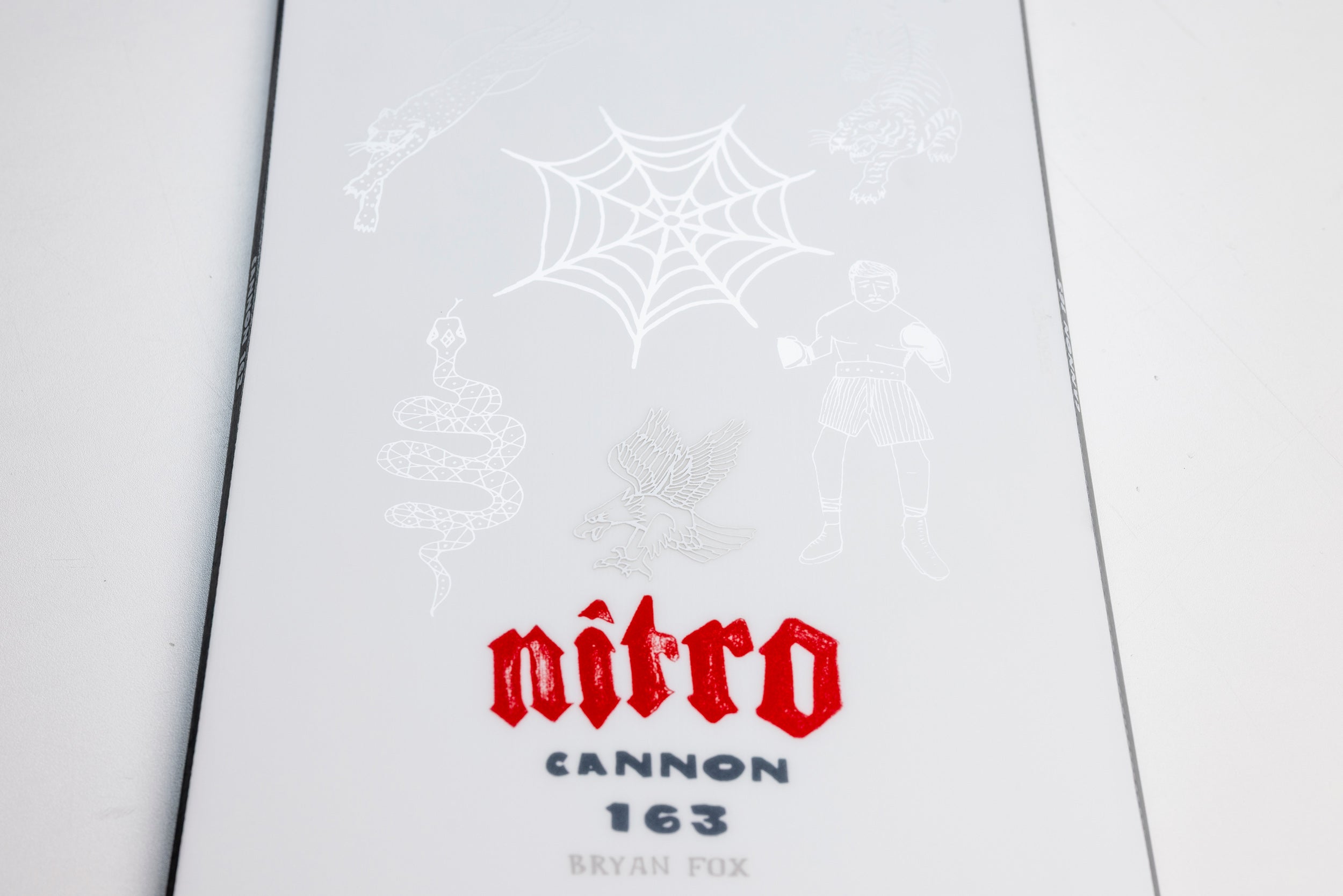 Nitro Cannon Quiver Series snowboard logo on a snow background, showcasing the 2027 Nitro snowboard design and branding.